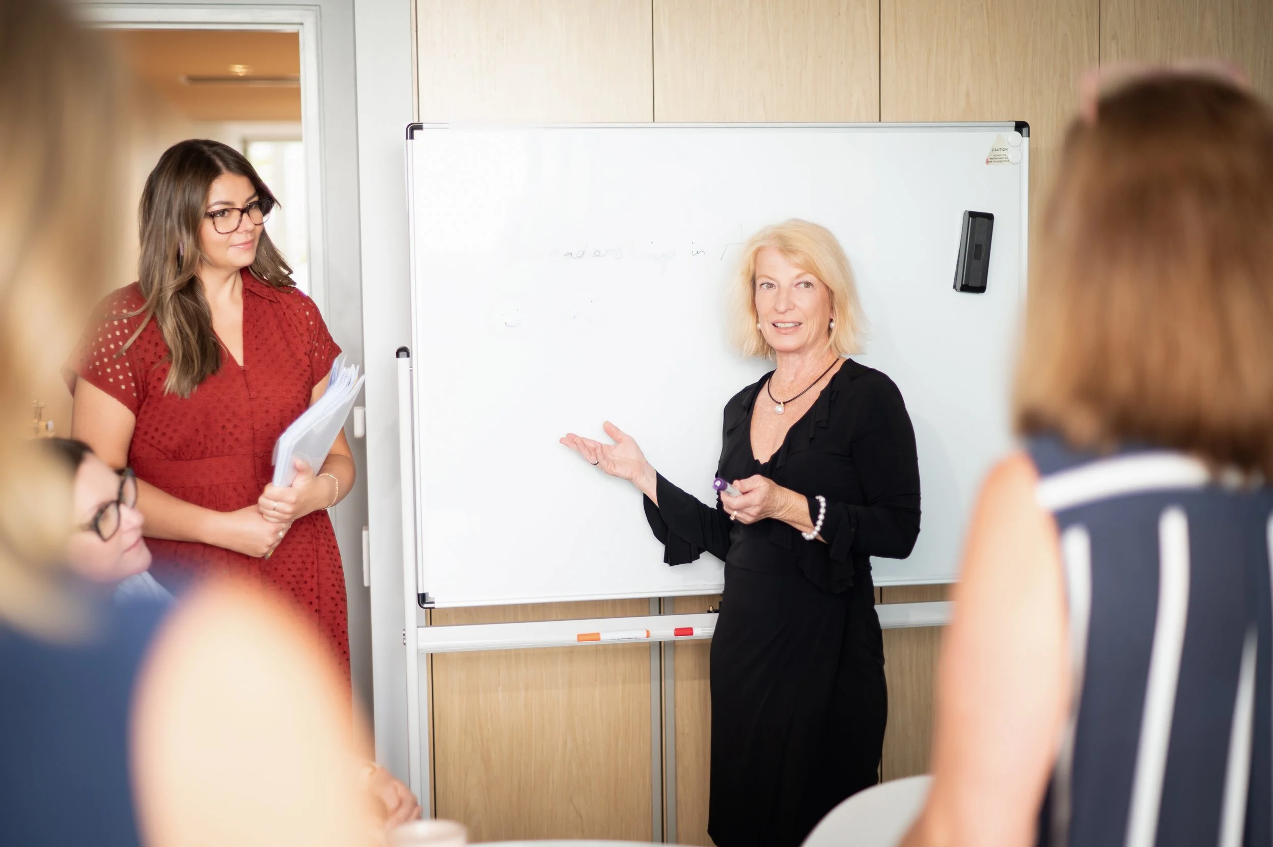 A consultant explaining something to a group of peers in a conference room.