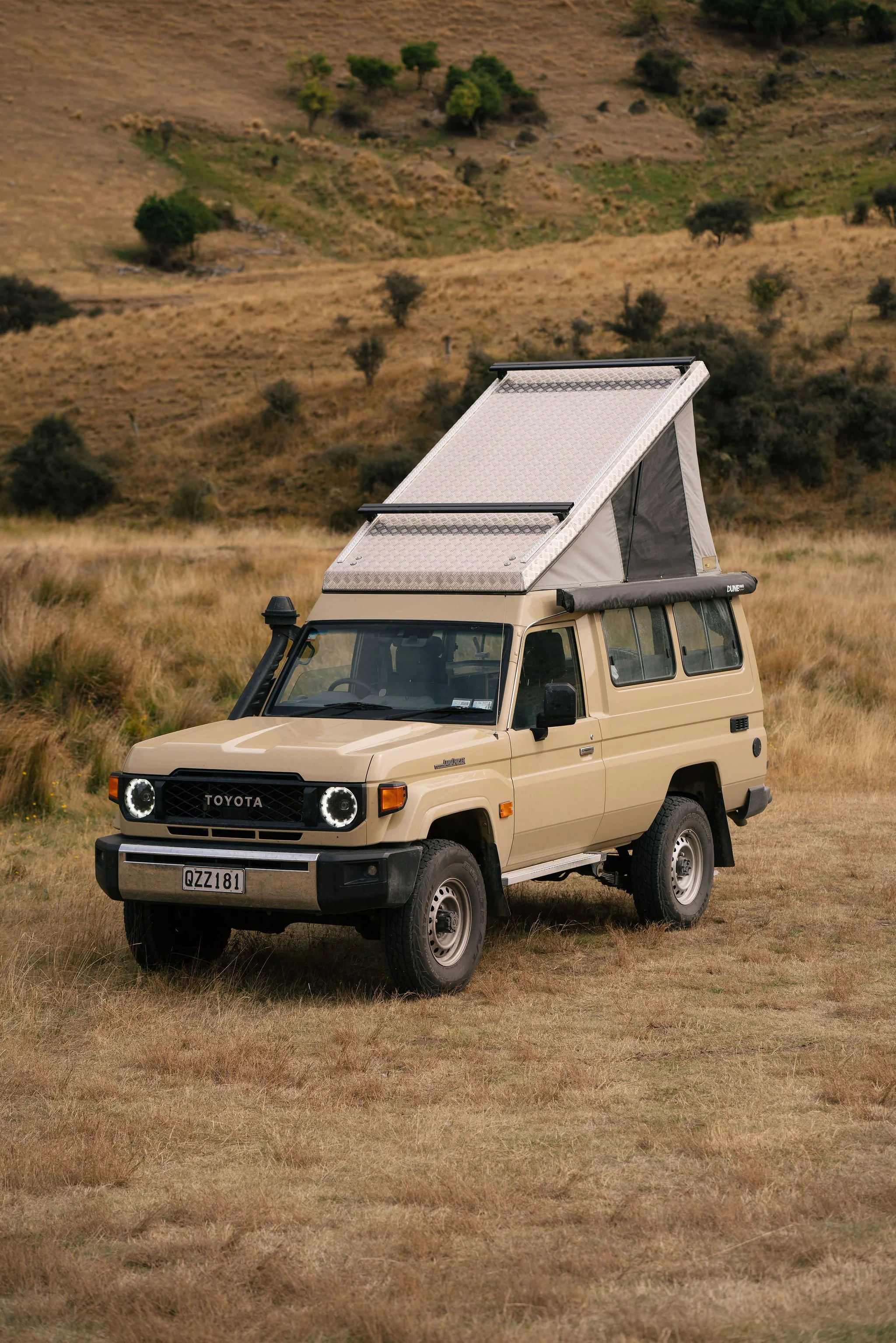 Toyota Land Cruiser 4WD with rooftop tent camping setup in NZ