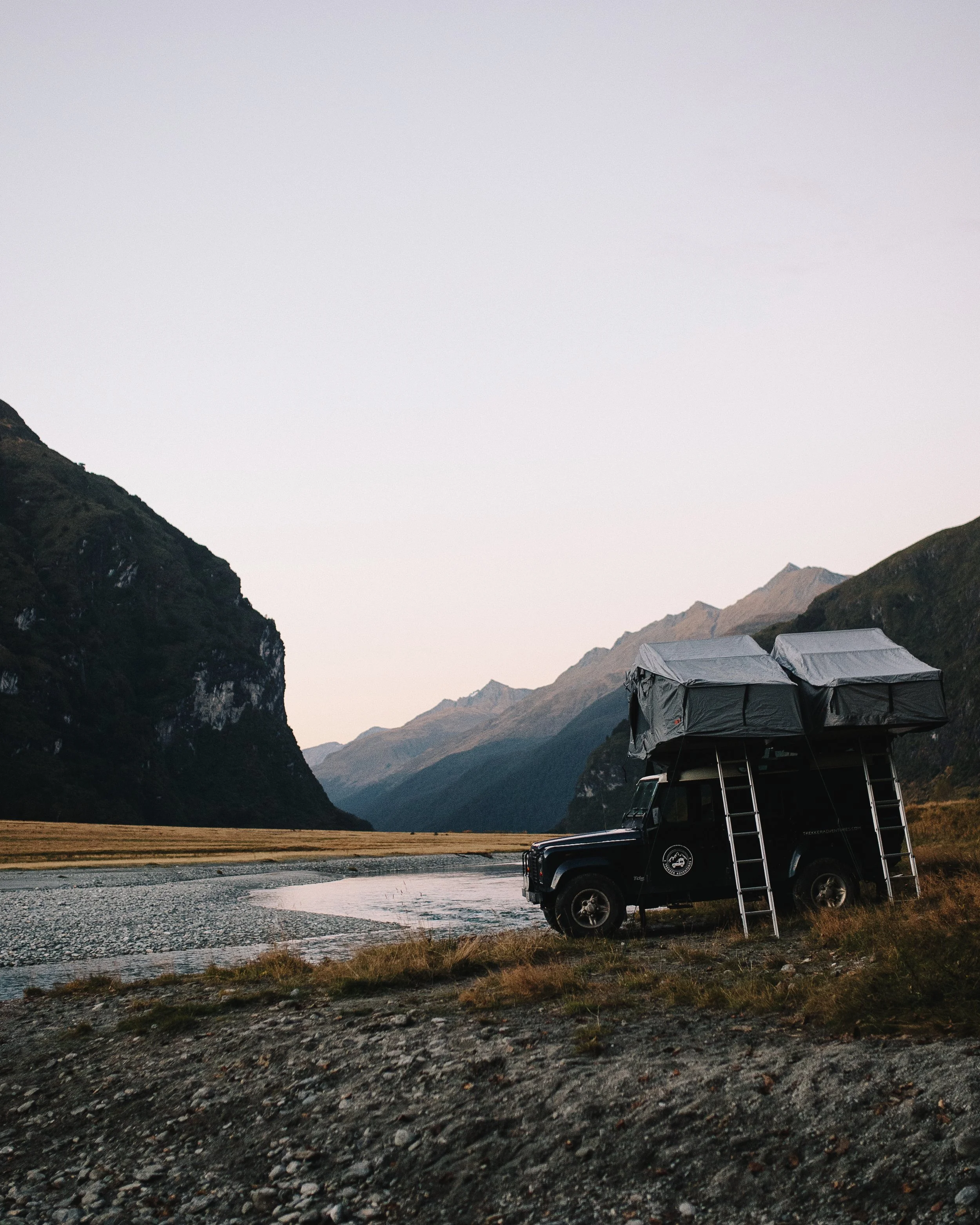Luxury 4WD with twin rooftop tents beside river valley in New Zealand – Trekker Adventures