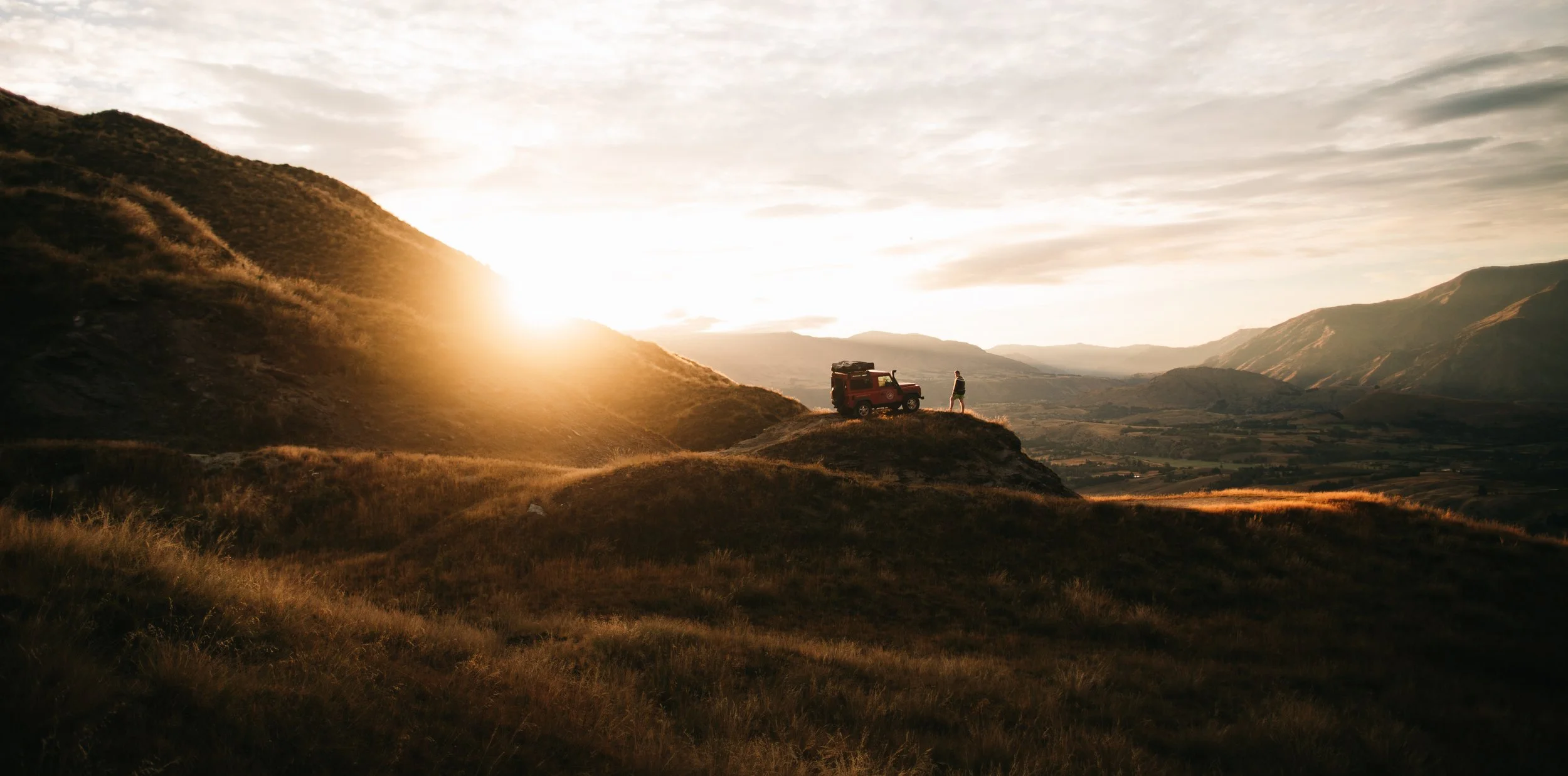 Rooftop-tent 4WD at sunset on South Island ridgeline