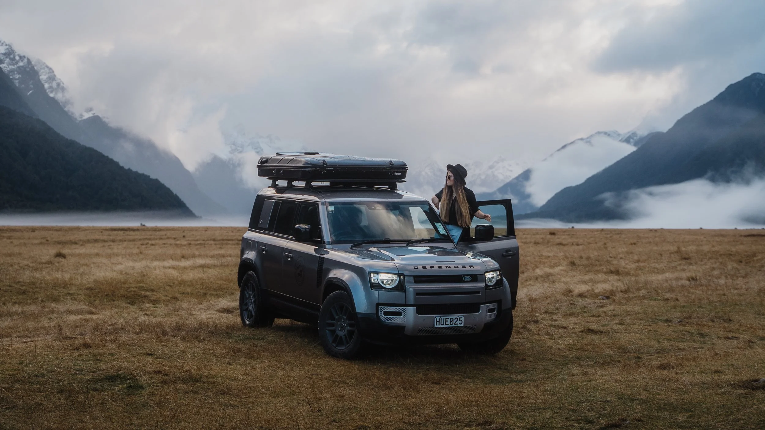Couple beside Land Rover Defender near Queenstown, New Zealand
