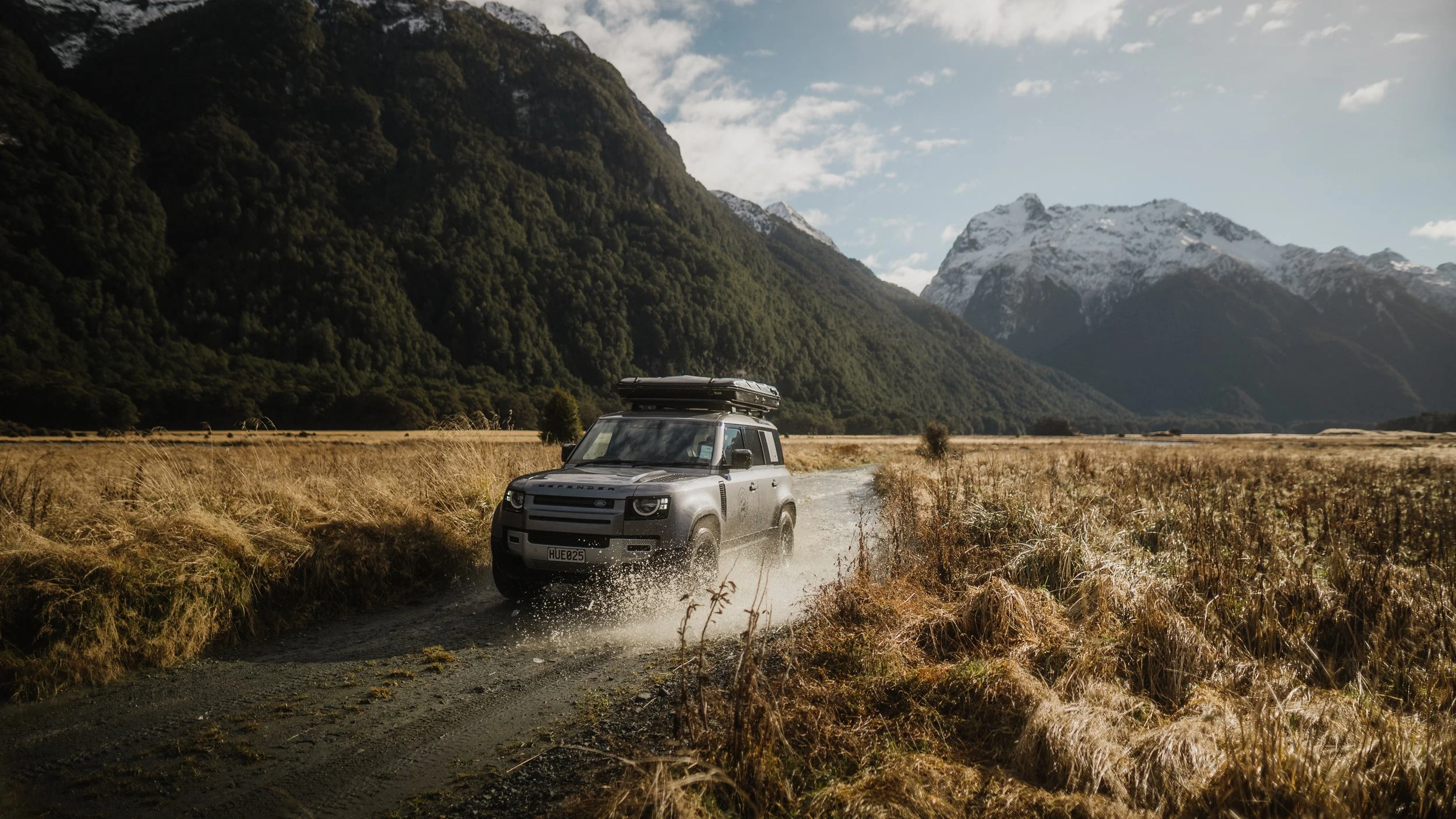 Land Rover Defender 4WD on gravel track in South Island valley – Trekker Adventures