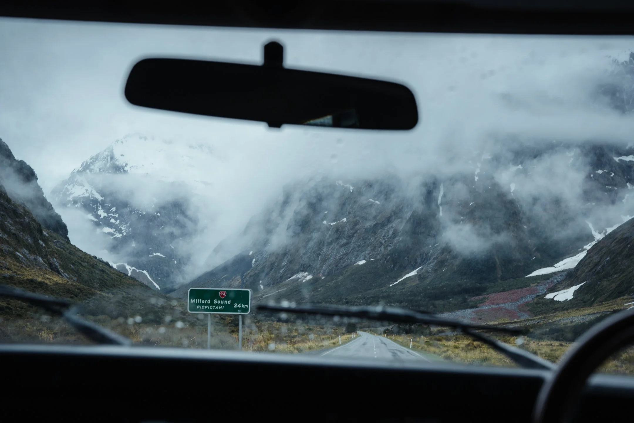 Driving to Milford Sound in rain through alpine pass, South Island NZ – Trekker Adventures