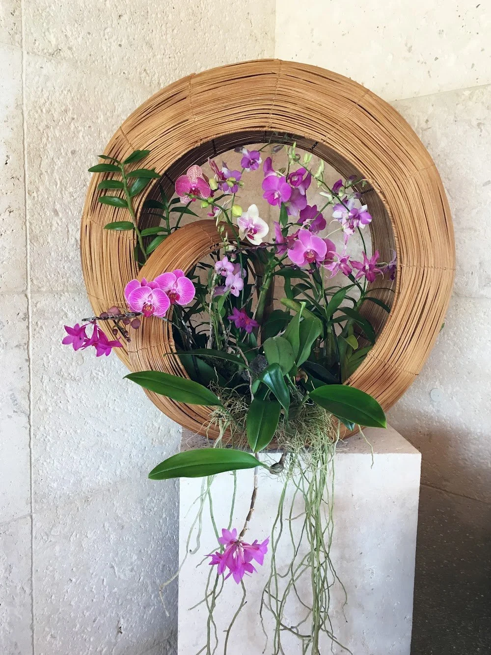 A custom poolside installation featuring orchids and natural materials.