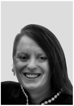 Black and white portrait of a smiling woman with long hair, wearing earrings and a necklace.
