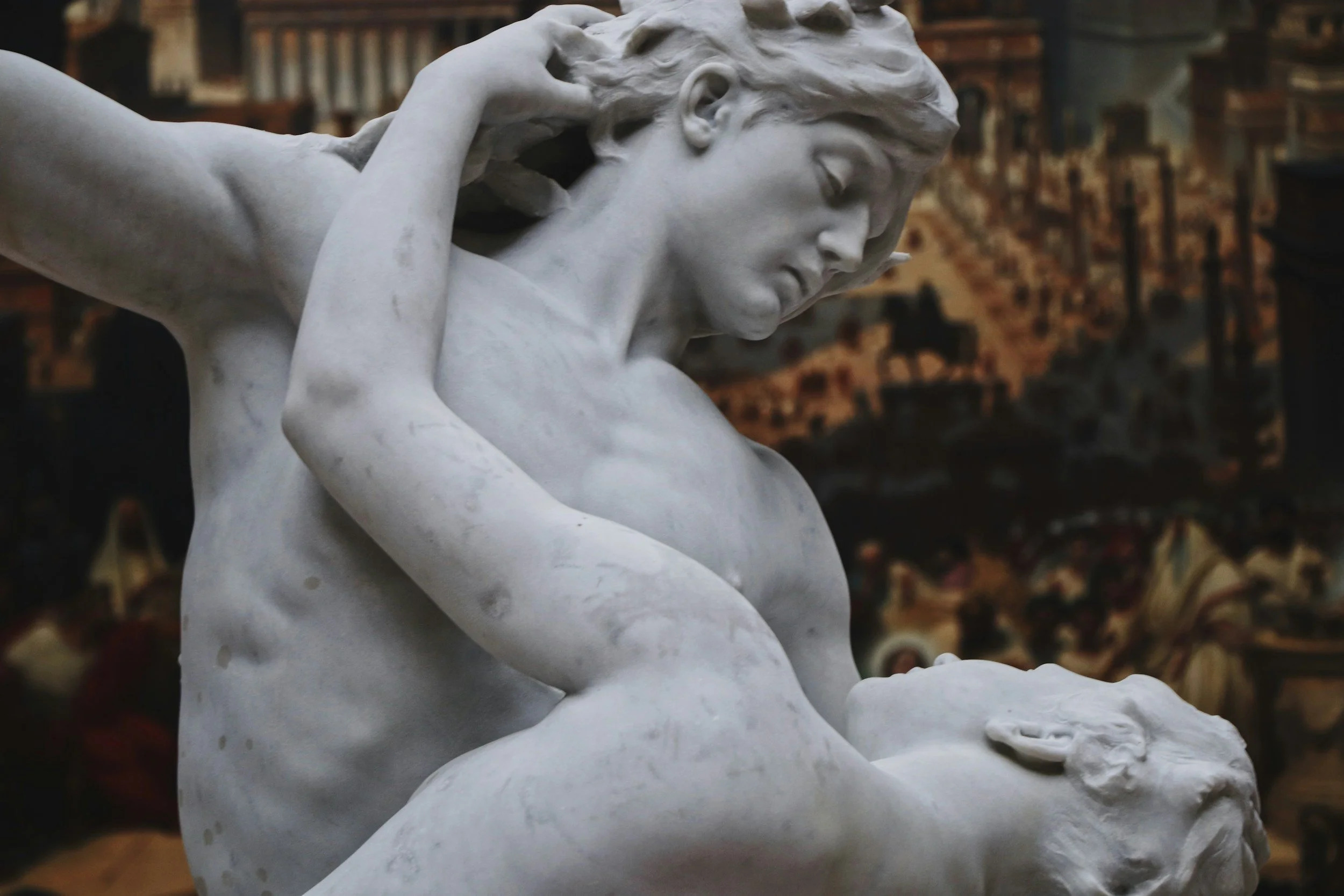 Escultura de mármol que representa a dos figuras humanas, una mujer y un hombre en una escena emocional intensa.