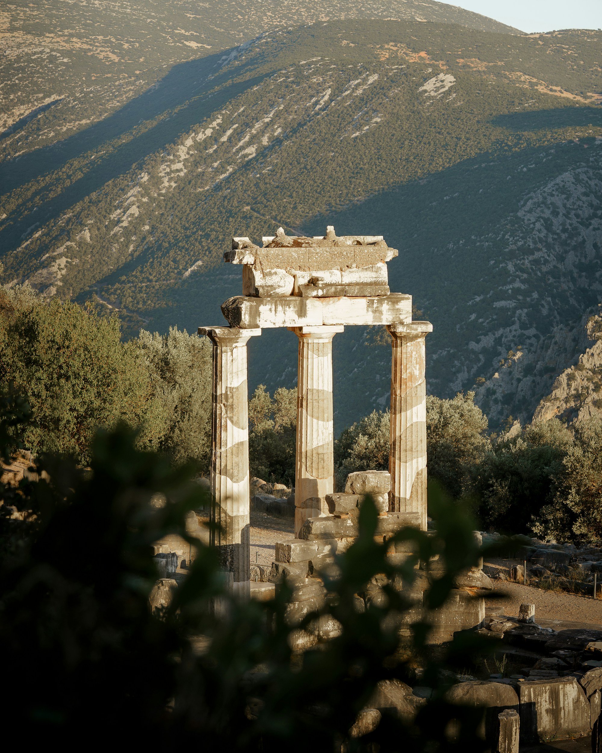 Ruinas de un templo antiguo con columnas en un paisaje montañoso.