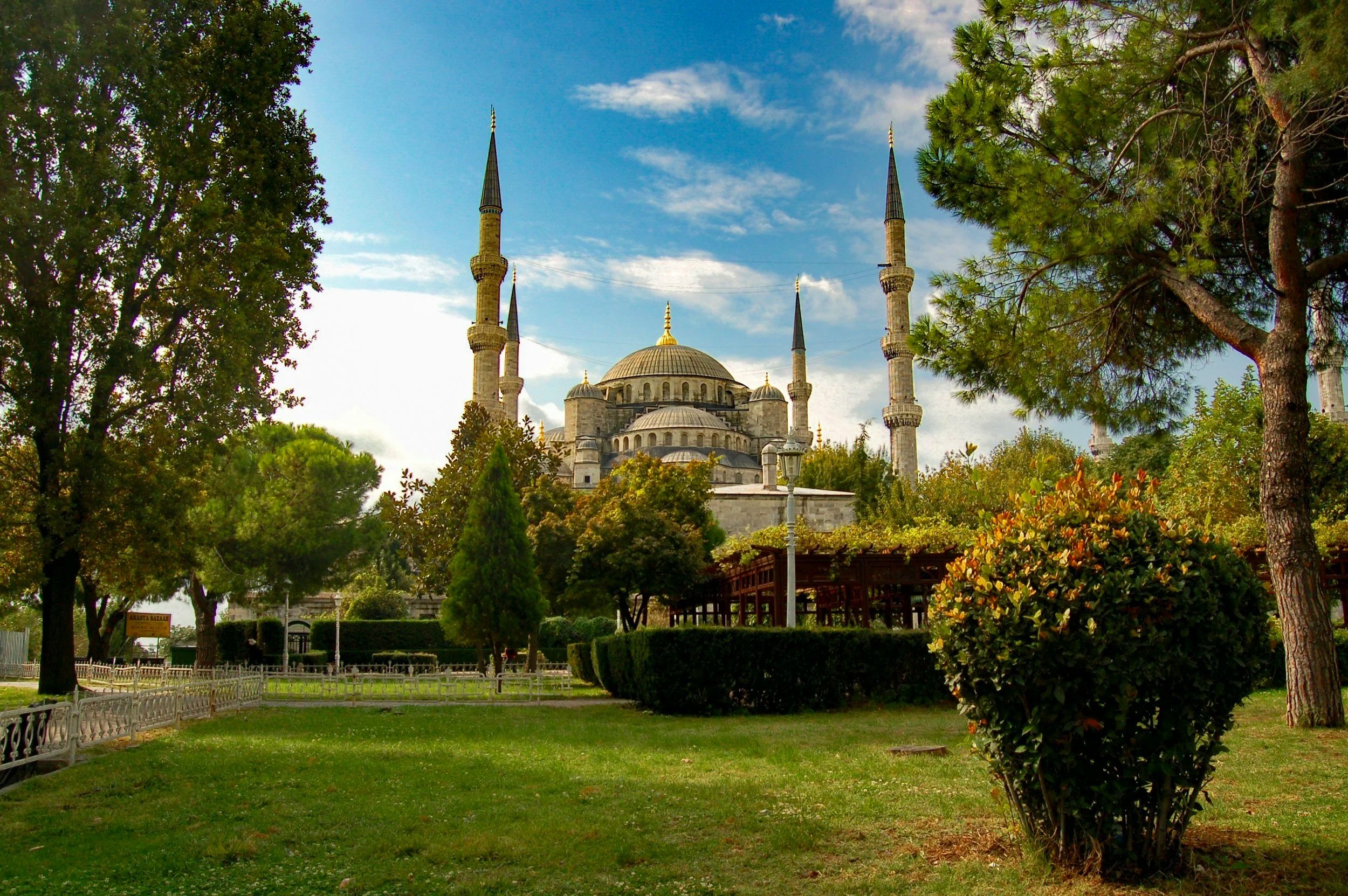 Vista del famoso Castillo de la Mezquita de Selimiye en Edirne, Turquía, rodeado de árboles y césped con un cielo parcialmente nublado.