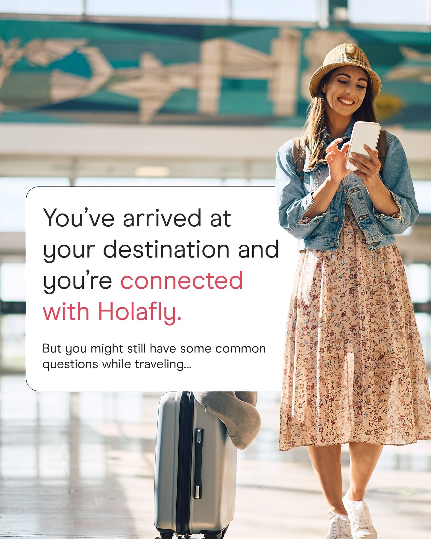 Mujer sonriente con sombrero, mochila, vestido floreado y sneakers, en aeropuerto, mirando su teléfono móvil junto a una maleta con ruedas