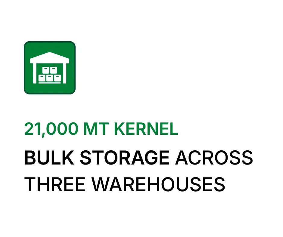 A green icon of a warehouse above the text '21,000 MT KERNEL' in green and 'BULK STORAGE ACROSS THREE WAREHOUSES' in black.