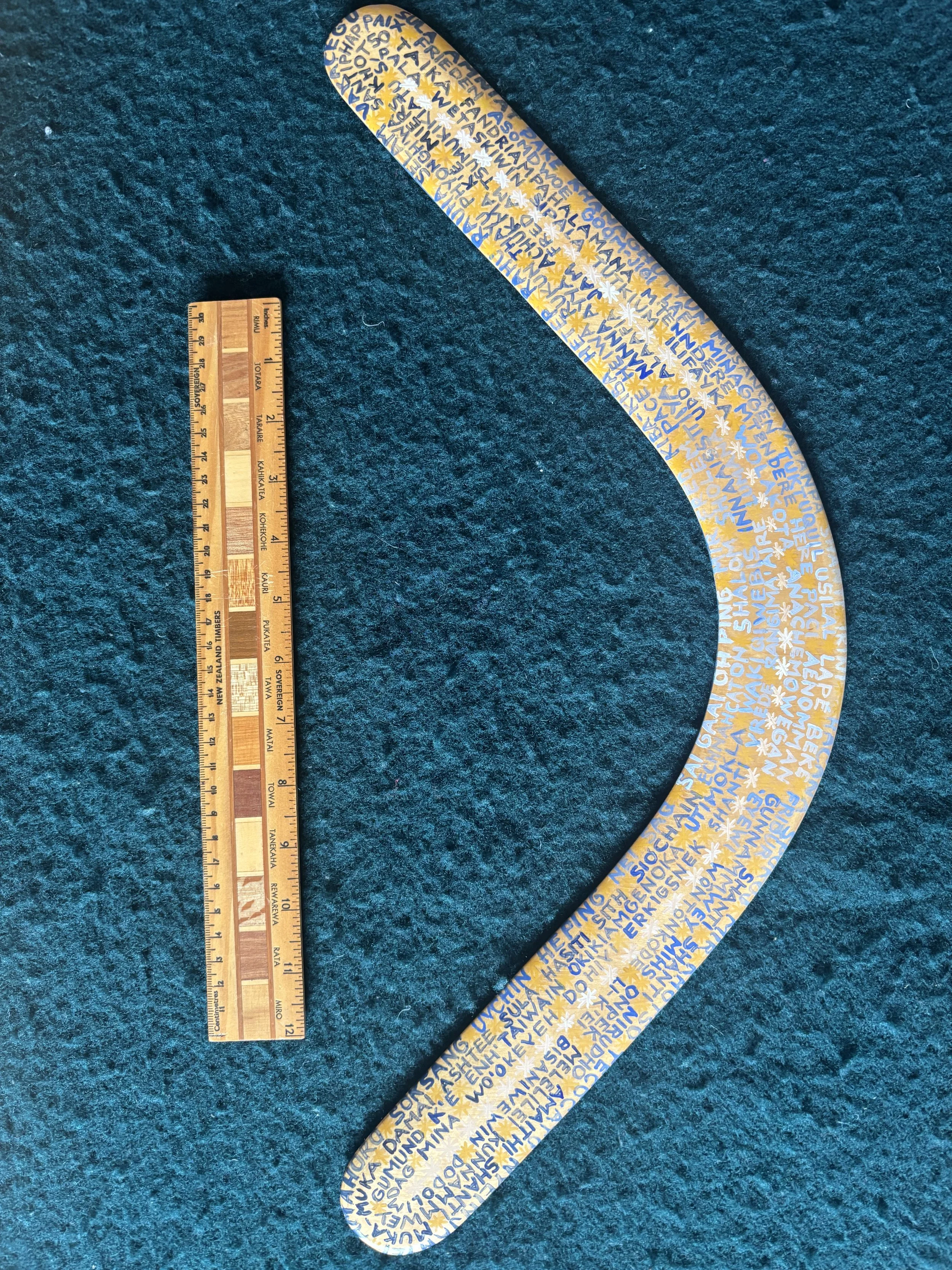 A laminated Ash wood rang bearing hand painted words of peace in 180 languages
