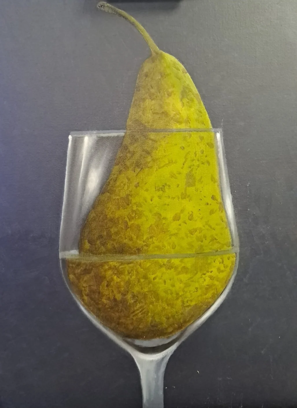 A pear submerged in water inside a wine glass with a gray background.