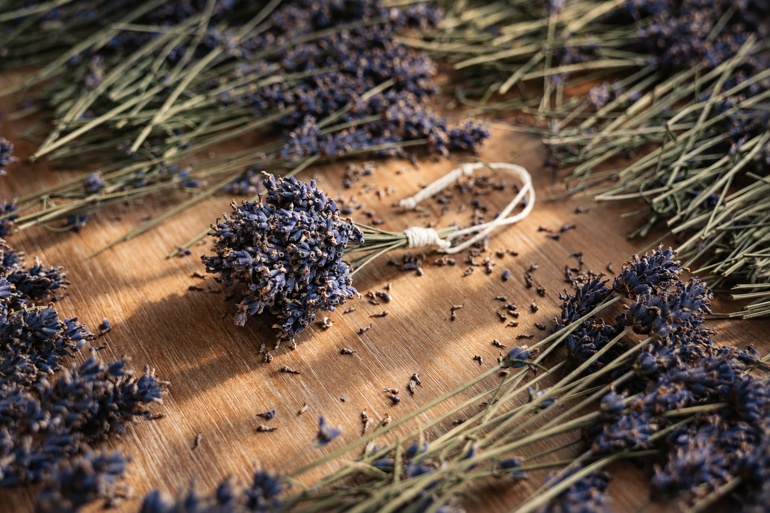 Losse en bundels gedroogde lavendel op een houten tafel.