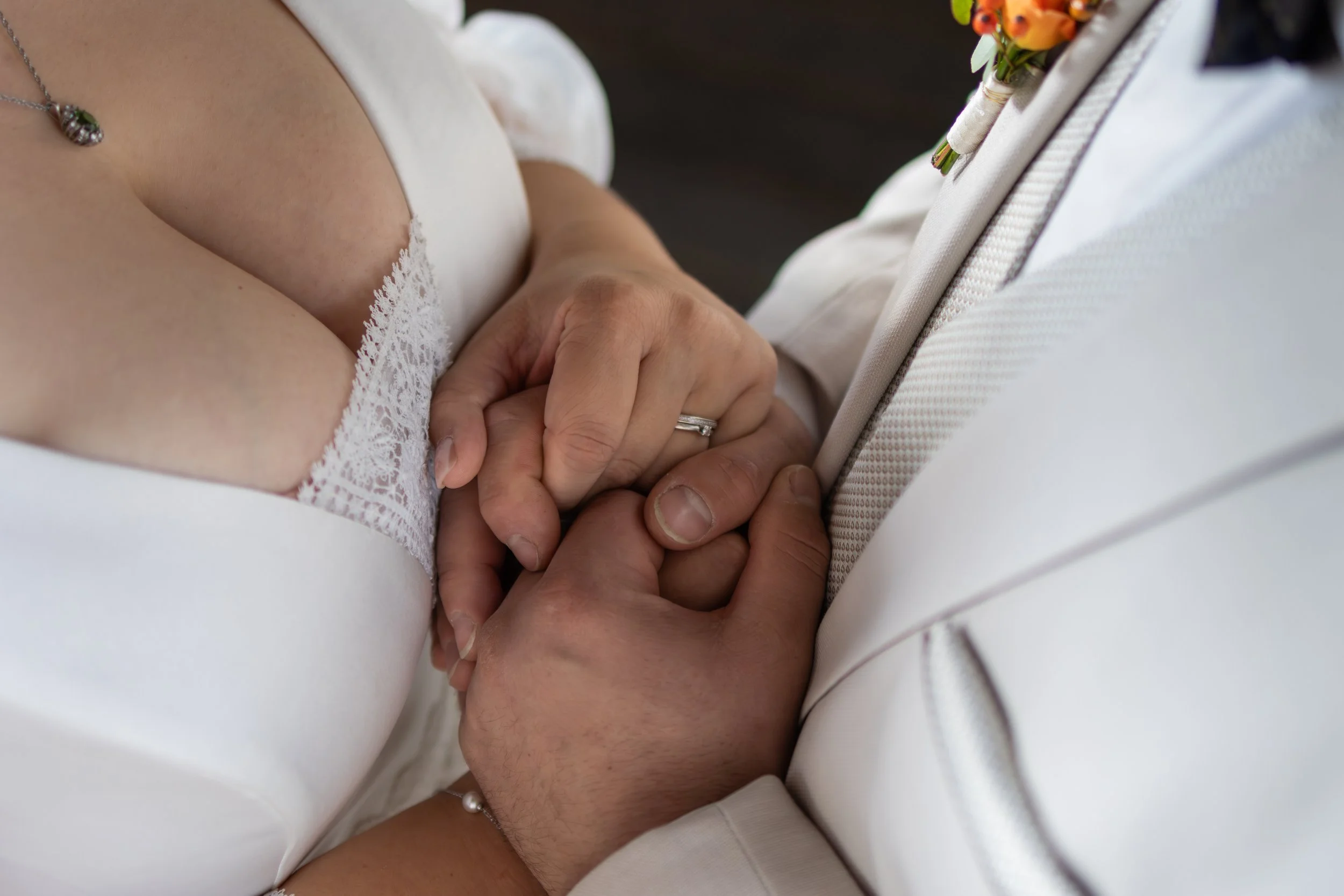 Händer von einem Brautpaar, die sich bei ihrer Hochzeit halten.