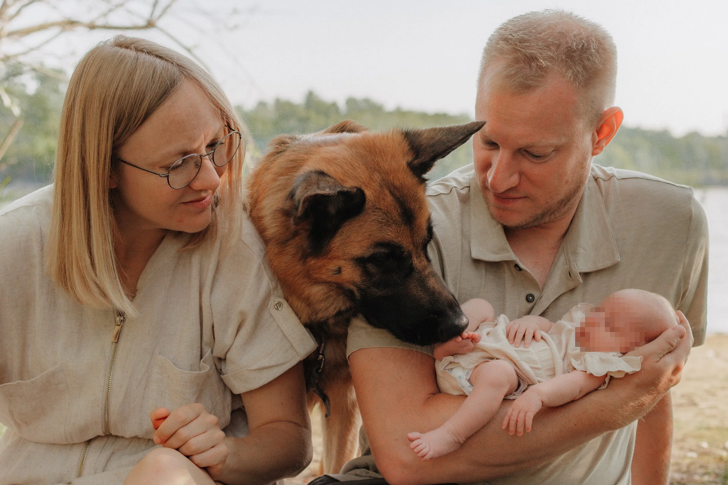Familie beim Himmelbett im Freien mit Baby, Hund und Mutter.