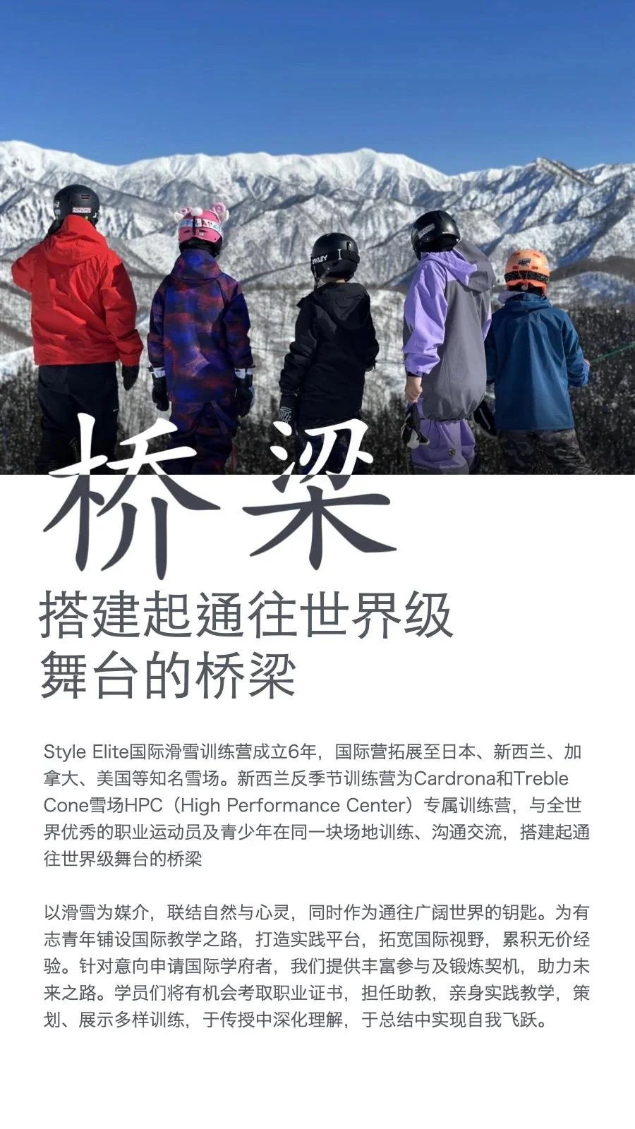Group of five skiers with helmets and winter gear looking at snow-covered mountains under a clear blue sky.