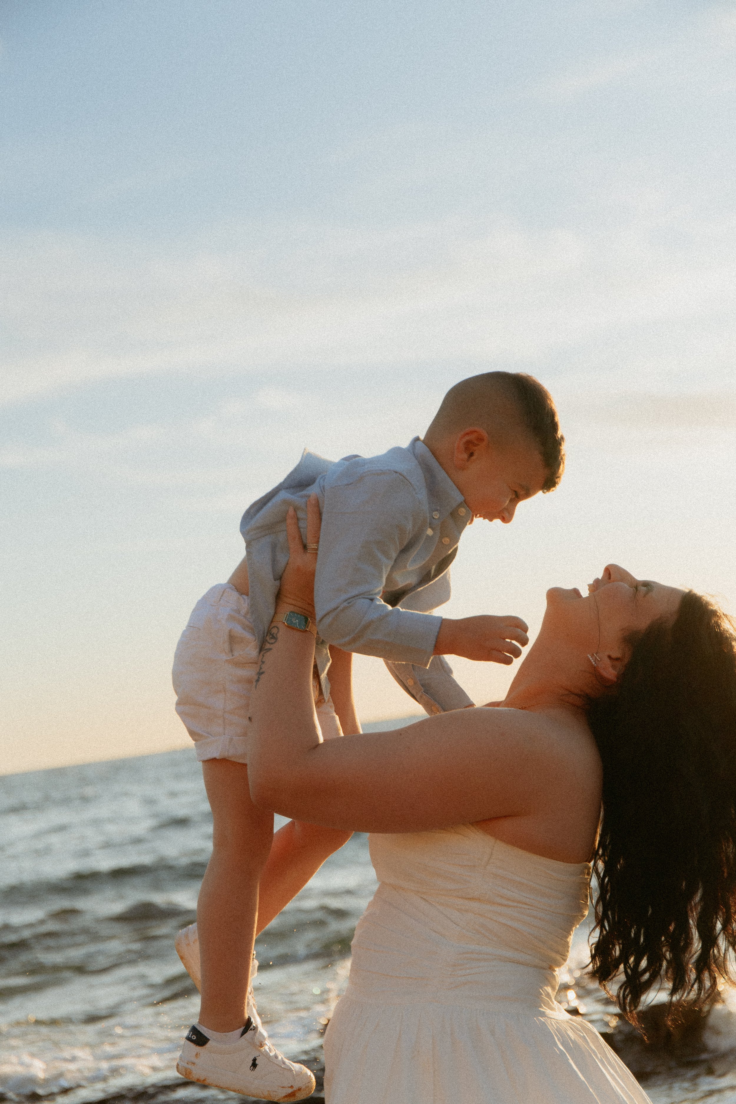 Mum holding son in the air at sunset on a Melbourne beach