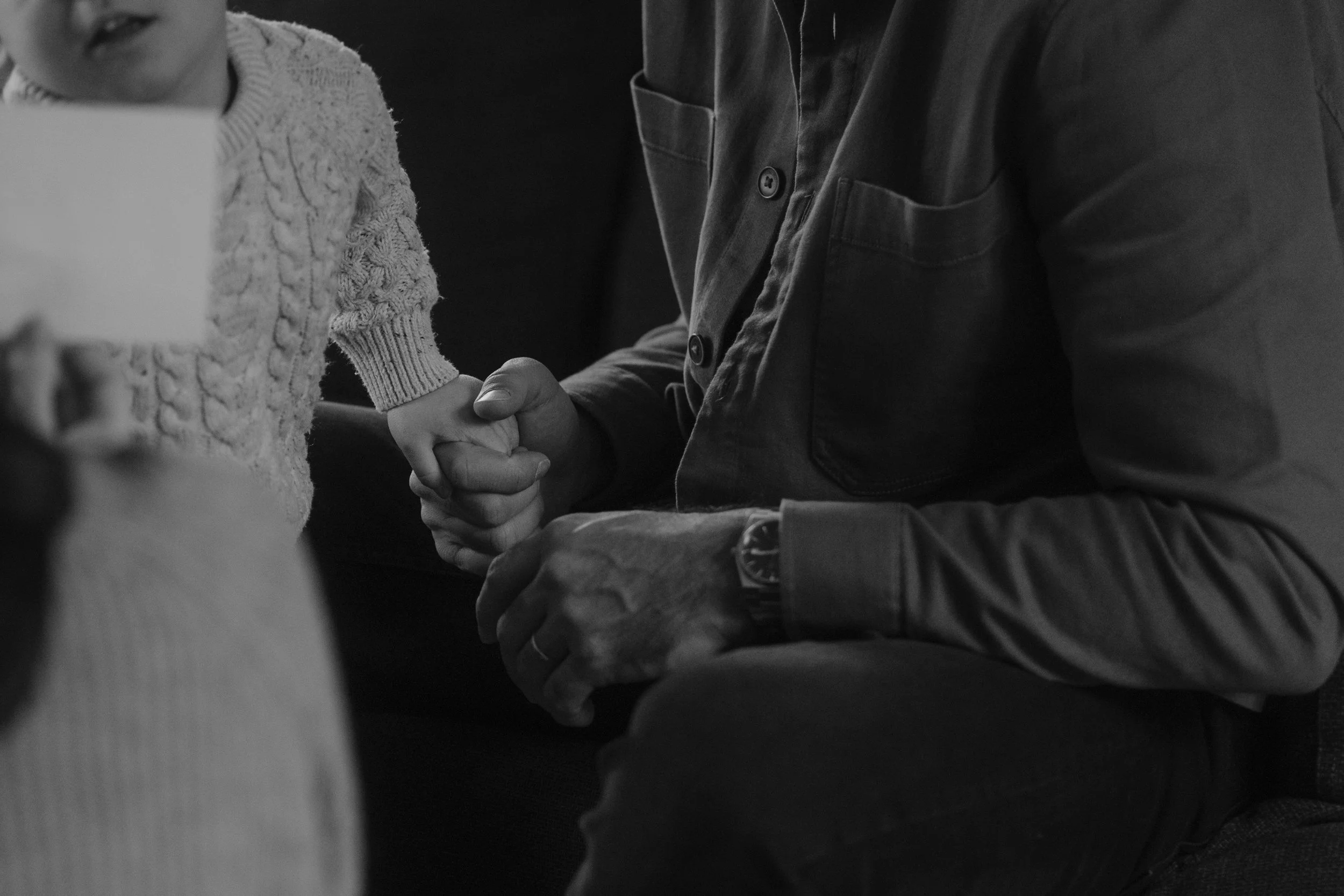 Un père et son fils se serrent la main, la scène est en noir et blanc et pleine de nostalgie.