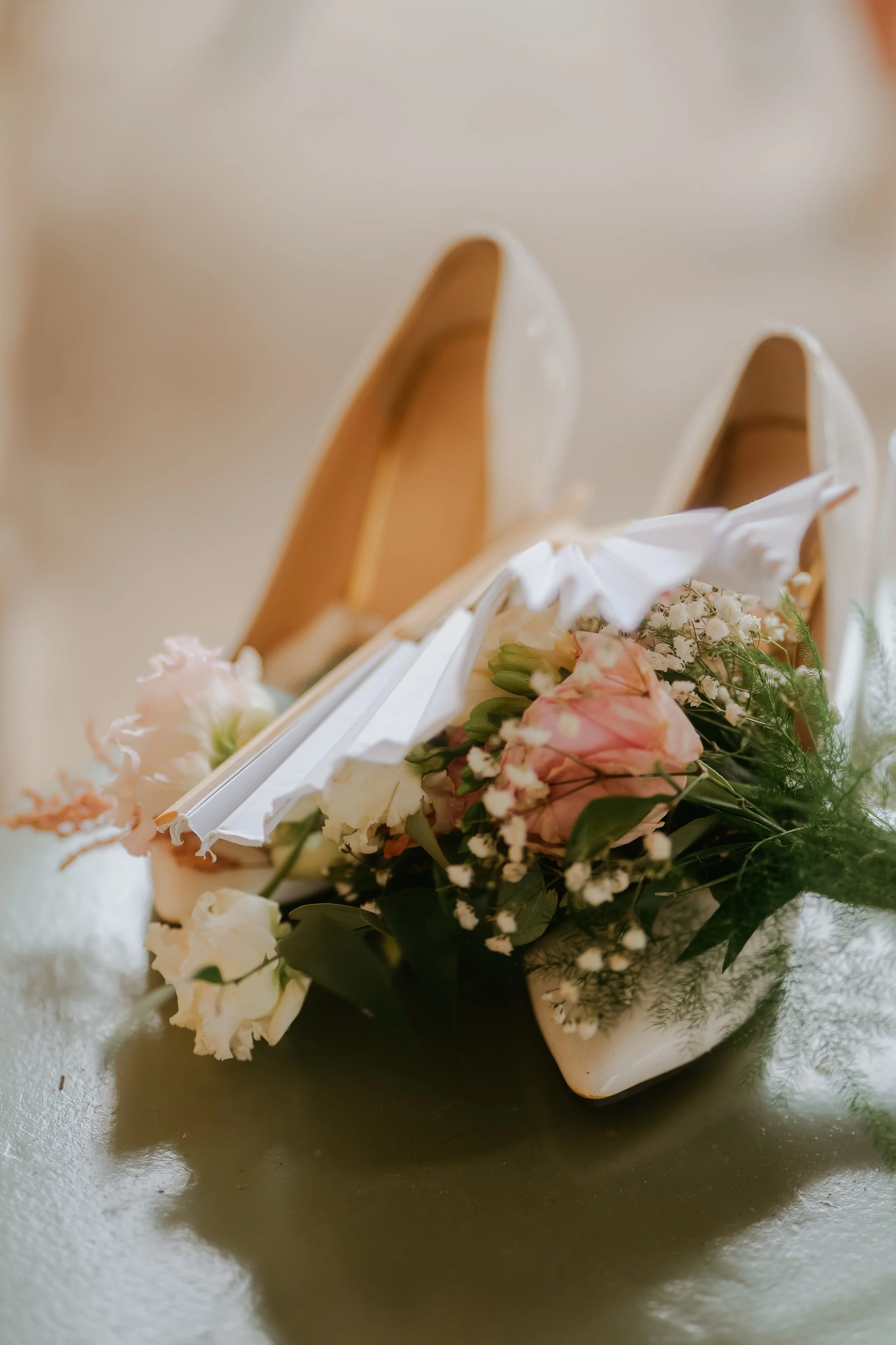 Chaussures de mariage avec une petite composition florale.