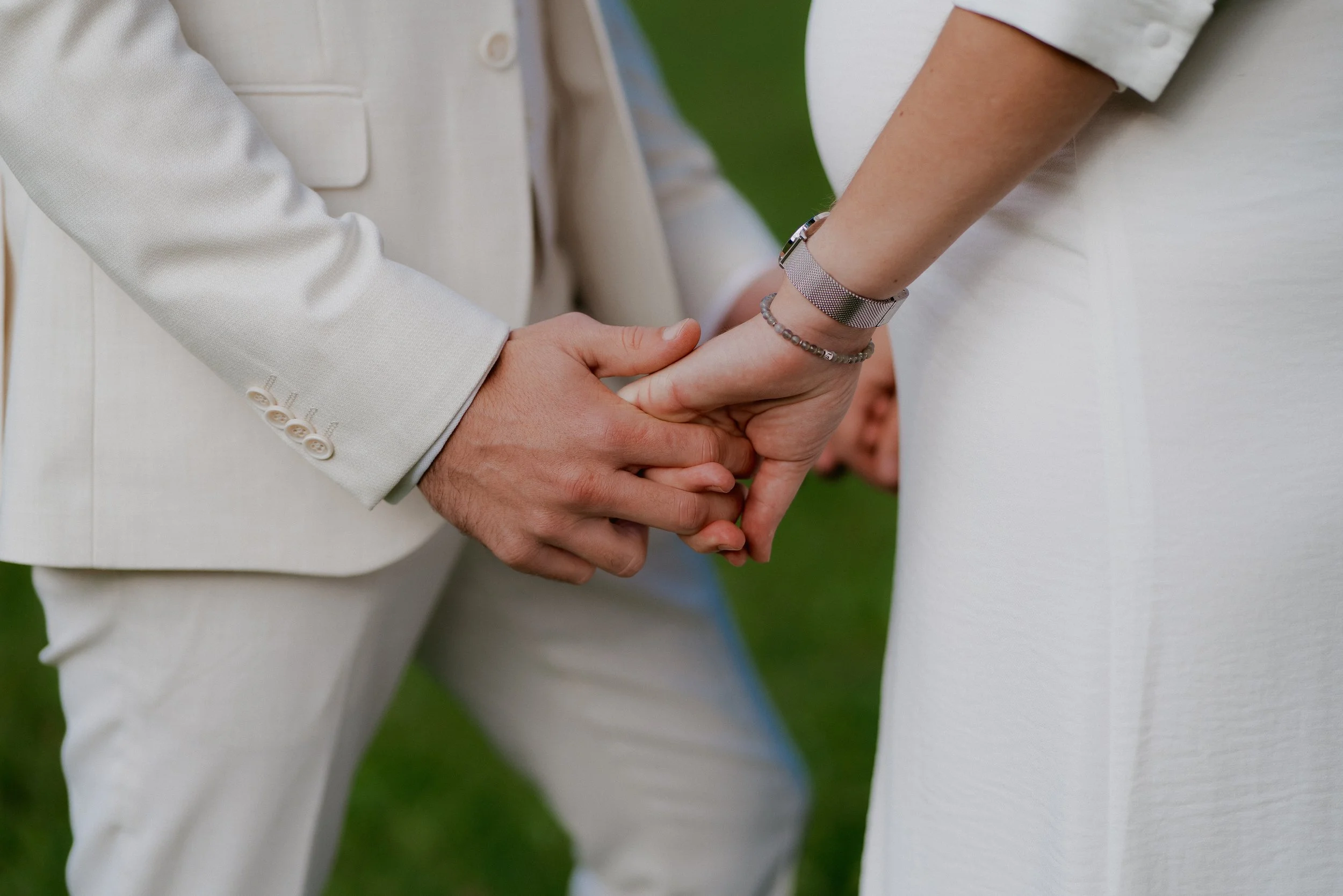 Un couple élégant  échange des alliances lors de leur mariage en plein air.