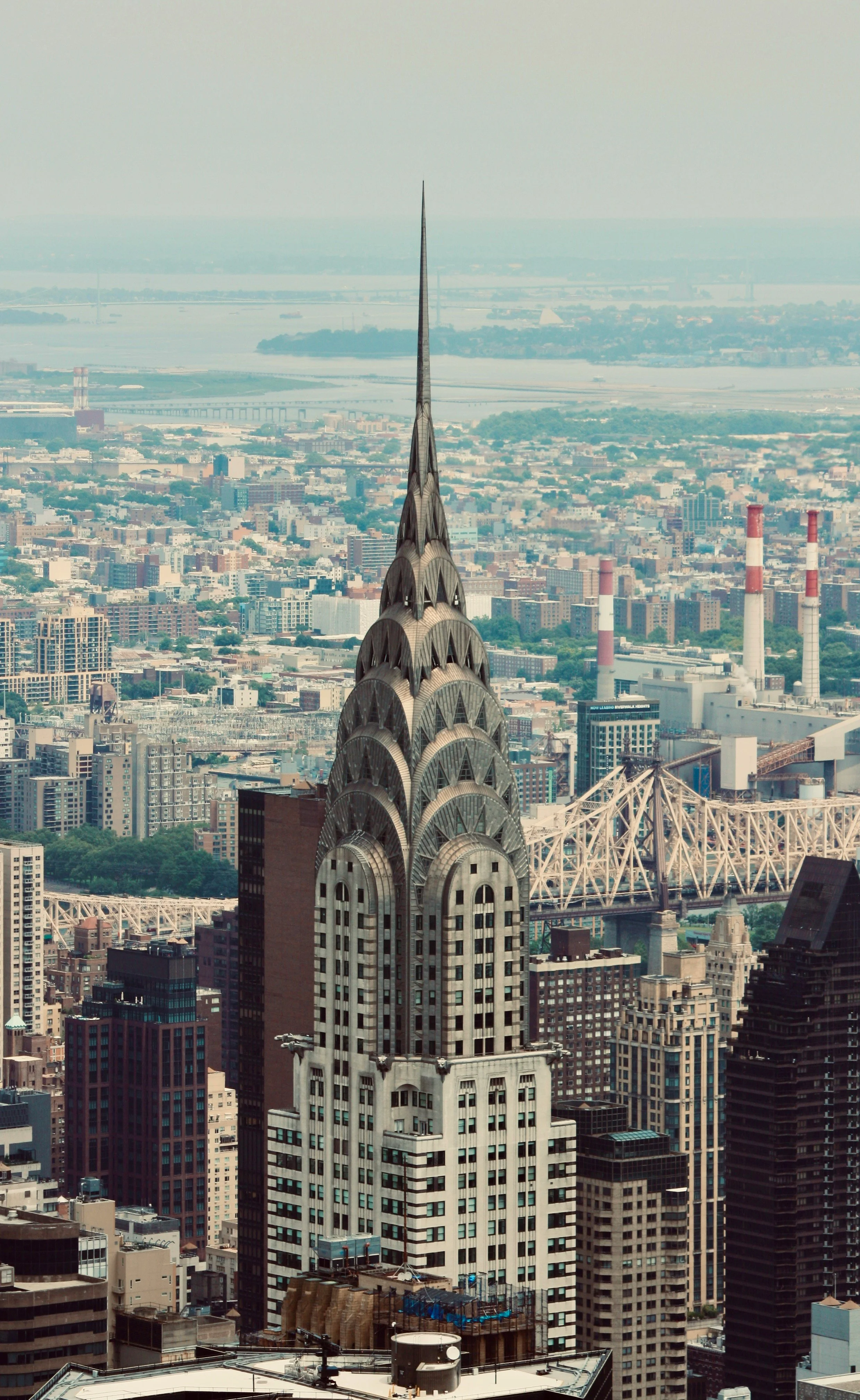 A high-rise building with an ornate spire in New York City surrounded by other skyscrapers.