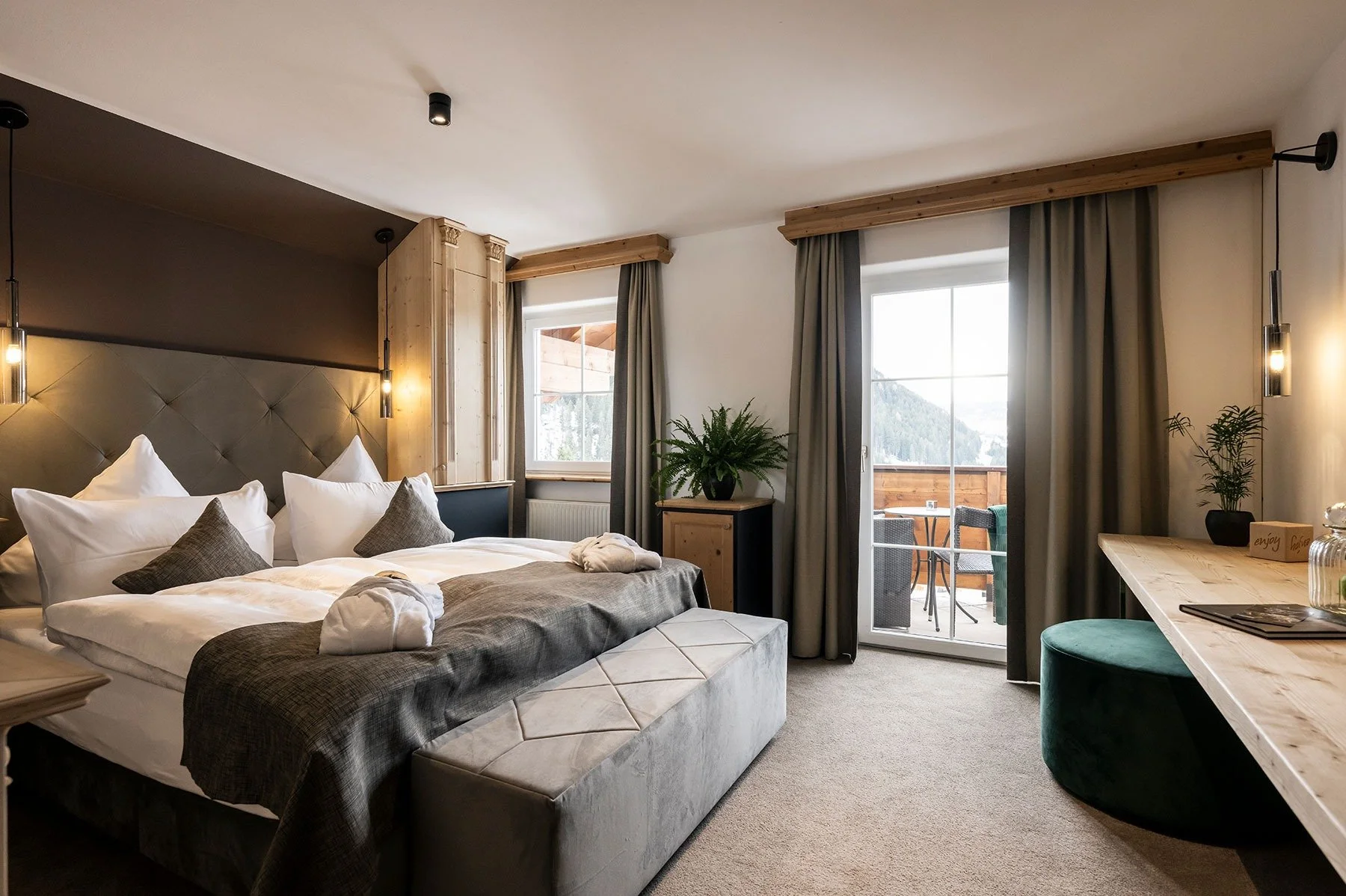 Elegant double bedroom with beautiful interior. Carpeted floor, large indulgent bed and sunny terrace.