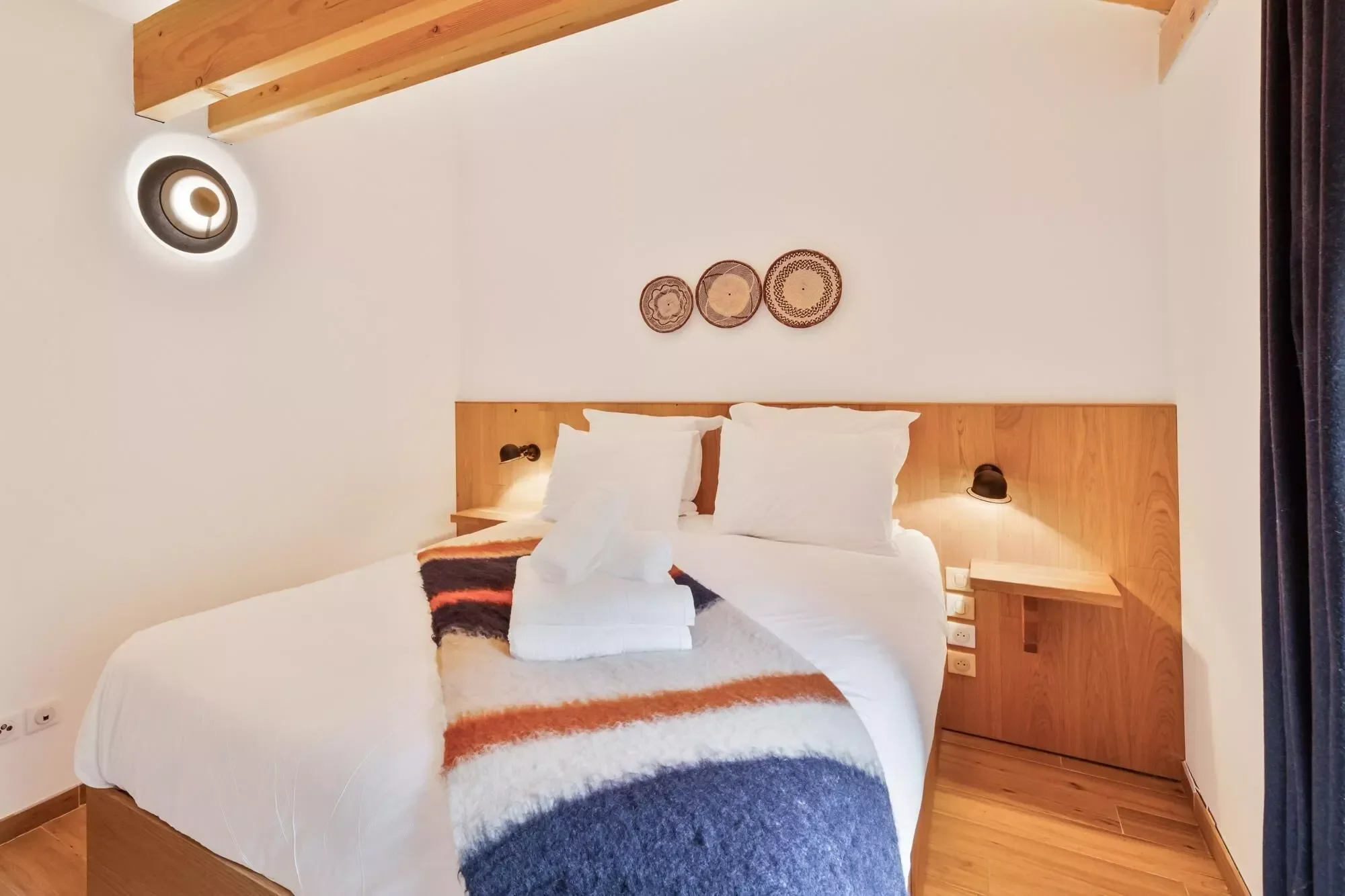Colourful double bedroom with alpine chic interiors and jazzy bed blanket.