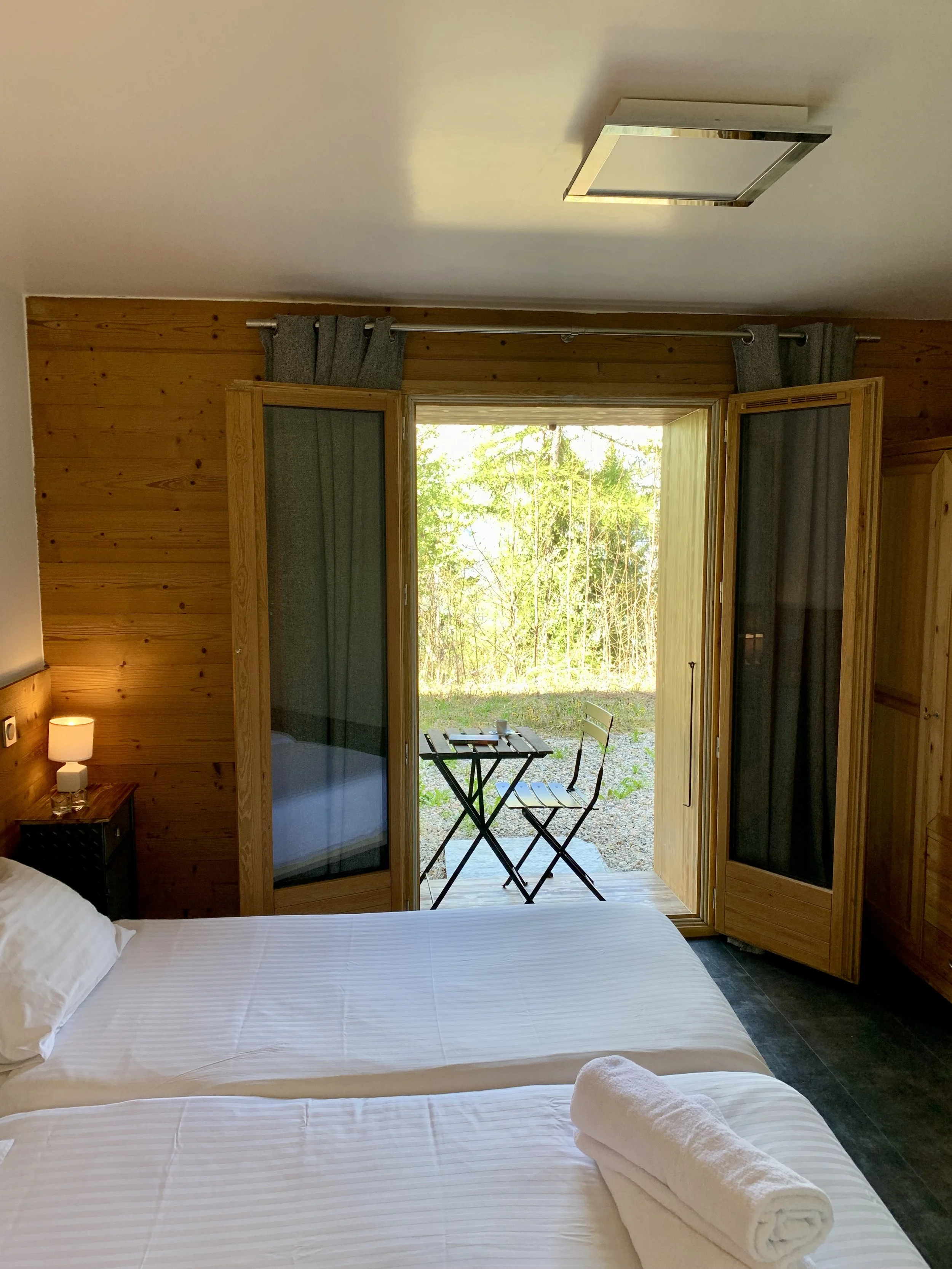 Twin bedroom with access to a lovely terrace through wide open doors. Pine interiors and well lit.