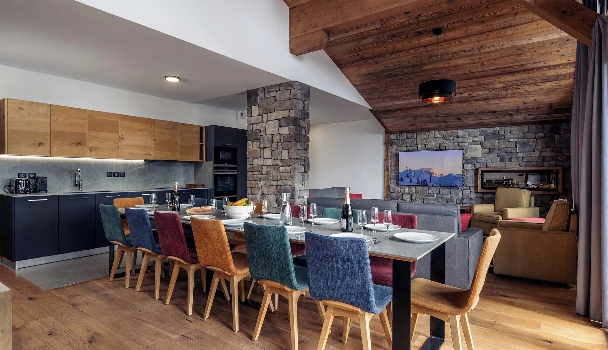 Colourful dining chairs, modern interior and open plan kitchen.