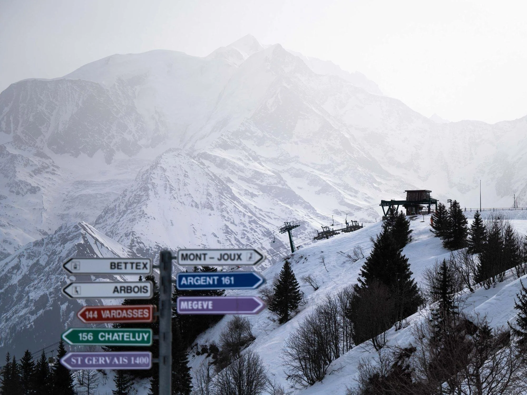 Clever signage at the top of the mountain describing routes in a colourful fashion over to Megeve, Arbois, Bettex, St Gervais and more with an atmospheric mountain the background.