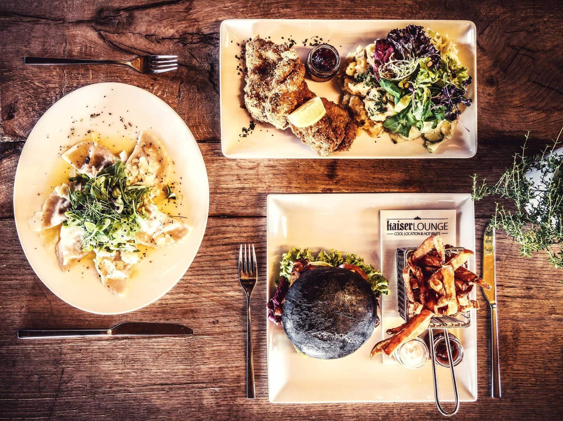Three different menu items from the restaurant at Tirol Lodge. Burger, Pasta and Schnitzel