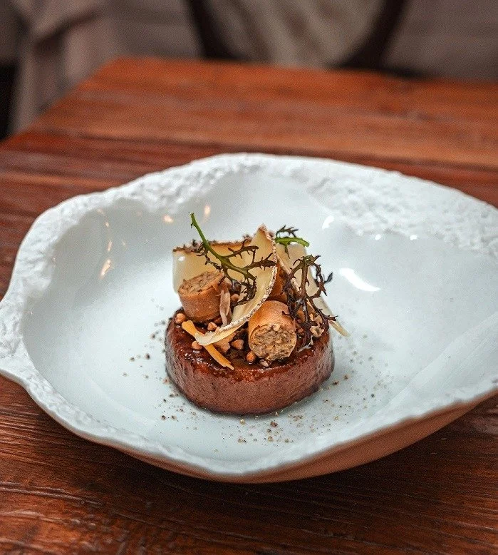 Beautifully presented plate of food with fine herbs and ingredients adorned on top.
