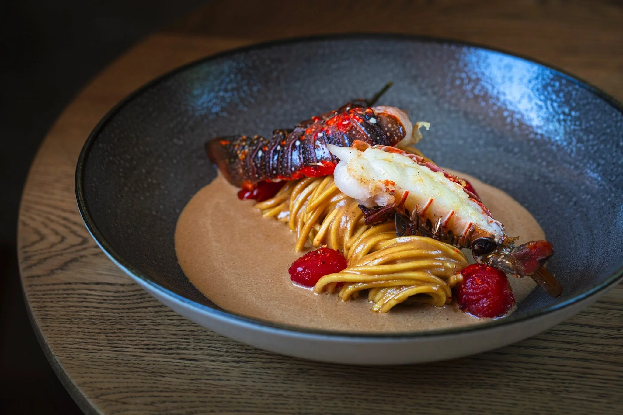 Beautiful pasta dish with lobster on top in a thick creamy sauce.