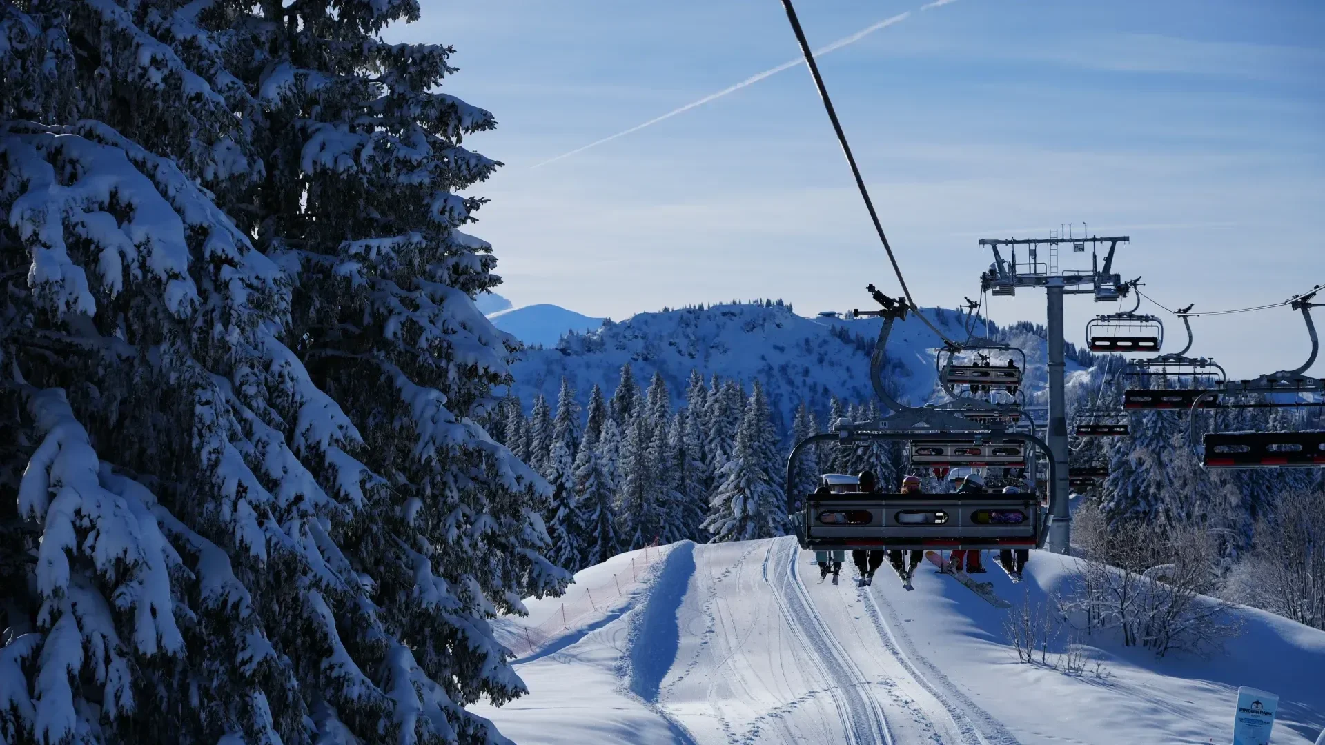Morzine ski area within the Portes du Soleil. Chairlift through the snow covered trees early in the morning.
