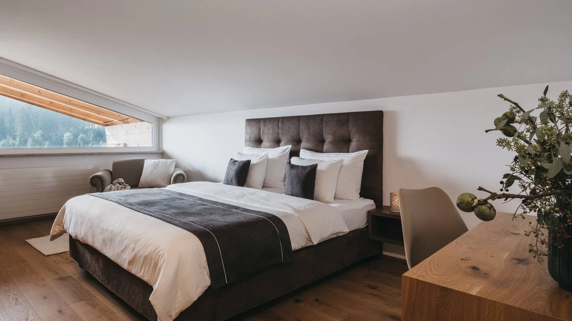 Plush double room in Vaya - Zell am See. Desk with brown bed and outside views.