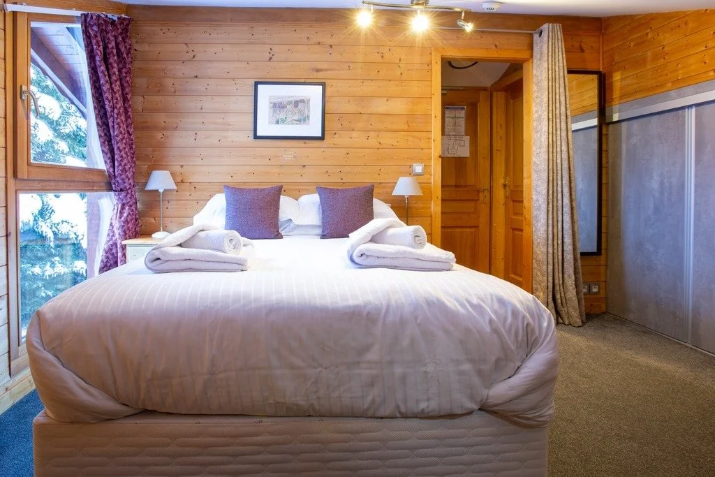 Large double room in Morzine, white double bedsheets and lovely views outside.
