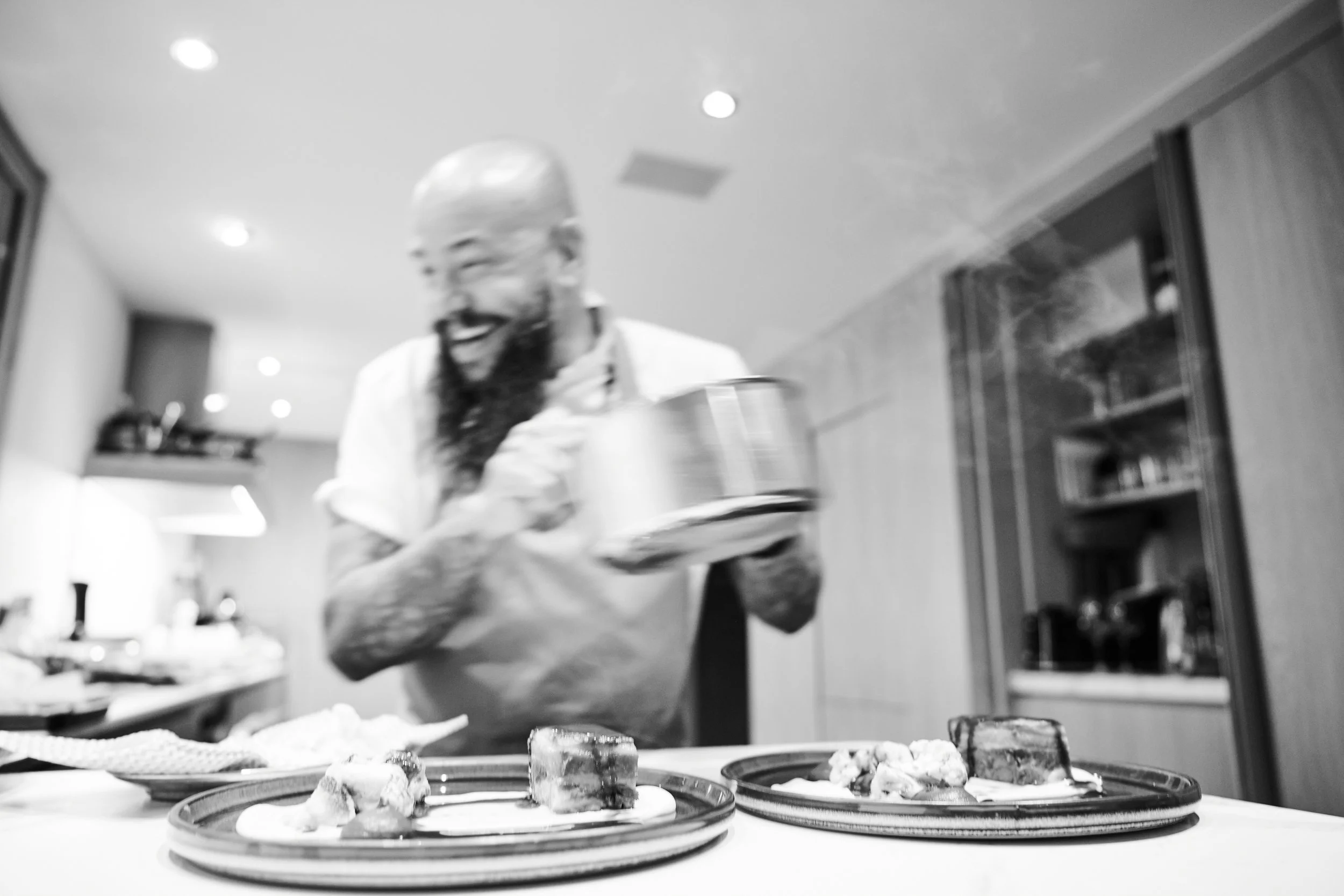 Private chef curating a fine looking dinner of meat in black and white.
