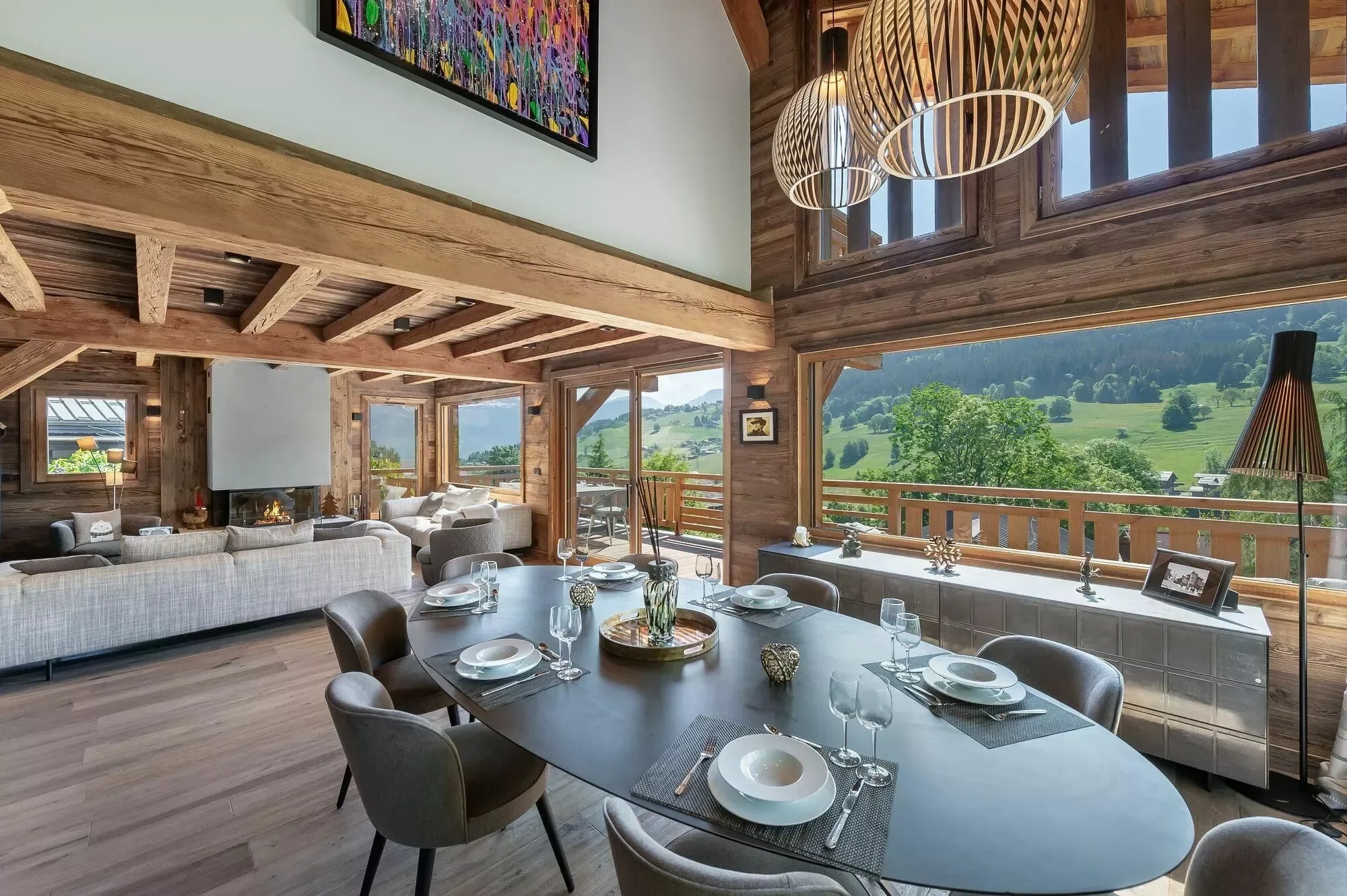 Dining table set for a meal. Plenty of space, calming interior design and beautiful mountain views out on the terrace beyond.