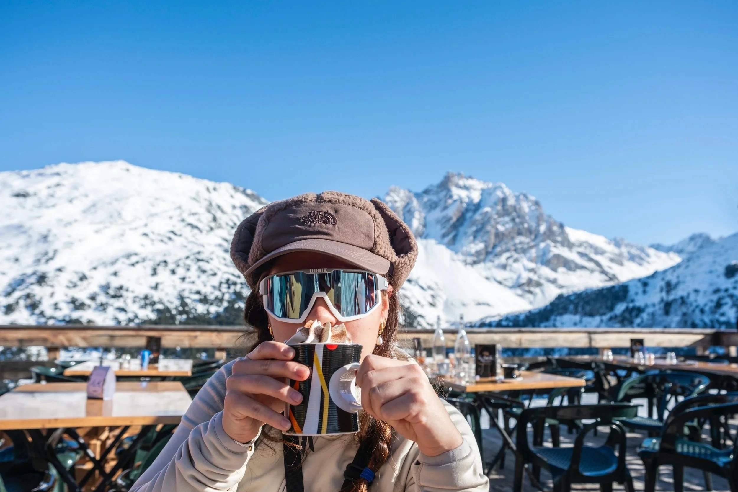 Girl enjoying hot chocolate on a terrace in Meribel.
