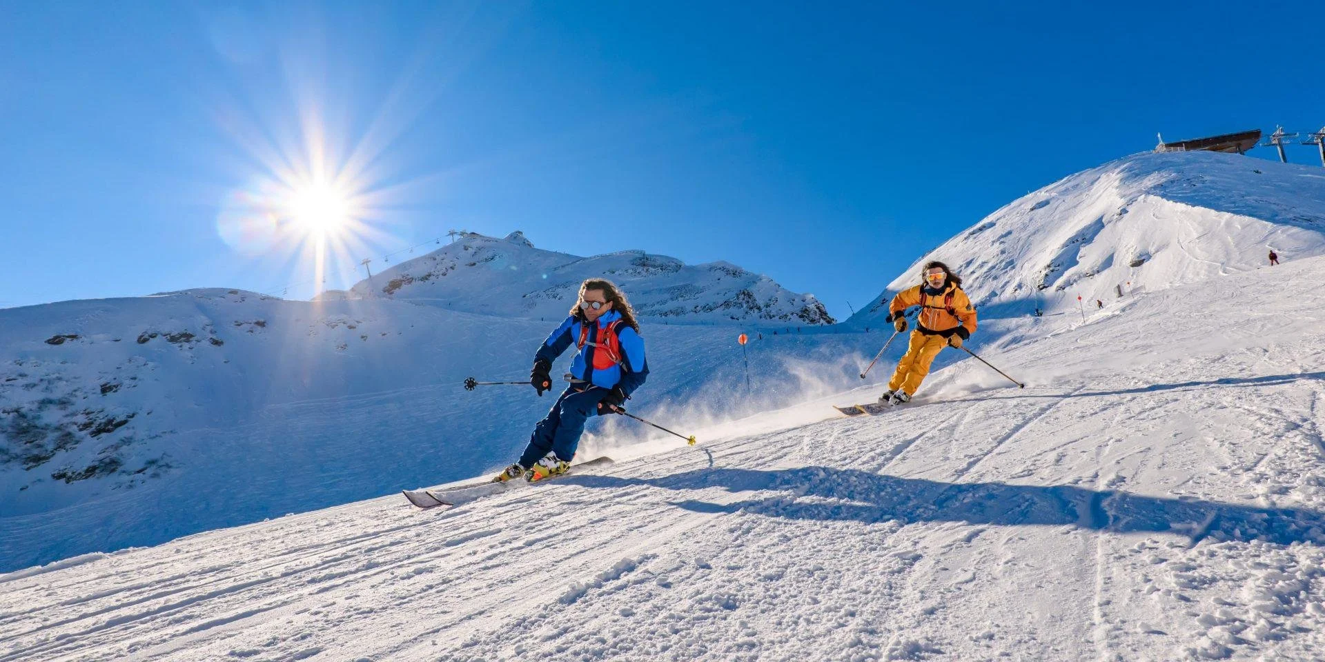 Two classic skiers in La Clusaz downhill skiing. Blue skies and fresh snow.