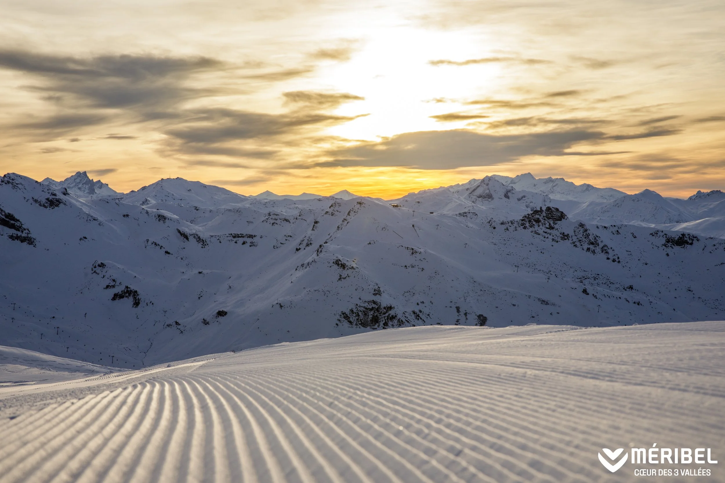 Sunset views over the piste in Méribel. Perfect white snow with mountain peaks in the distance.