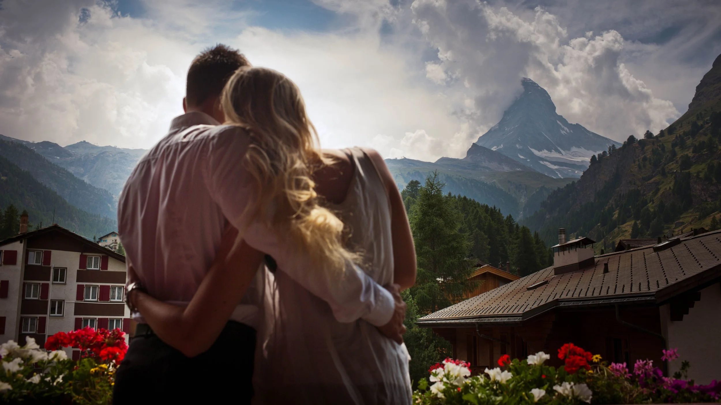 A couple hugging with a mountain and village in the background