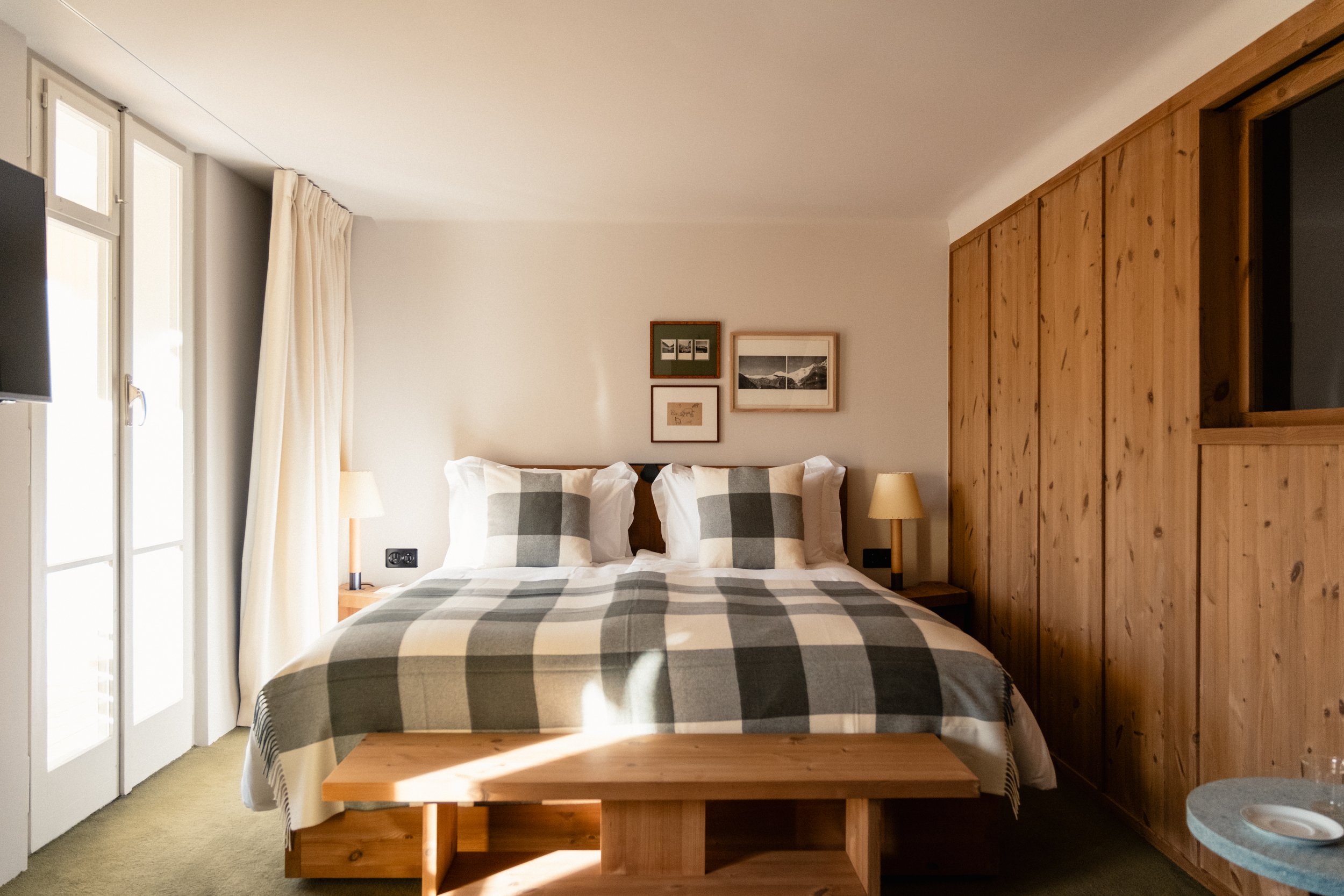 Large patchwork double bed with beautiful sunlight streaming through the windows. Wooden panelling and soft furnishings.
