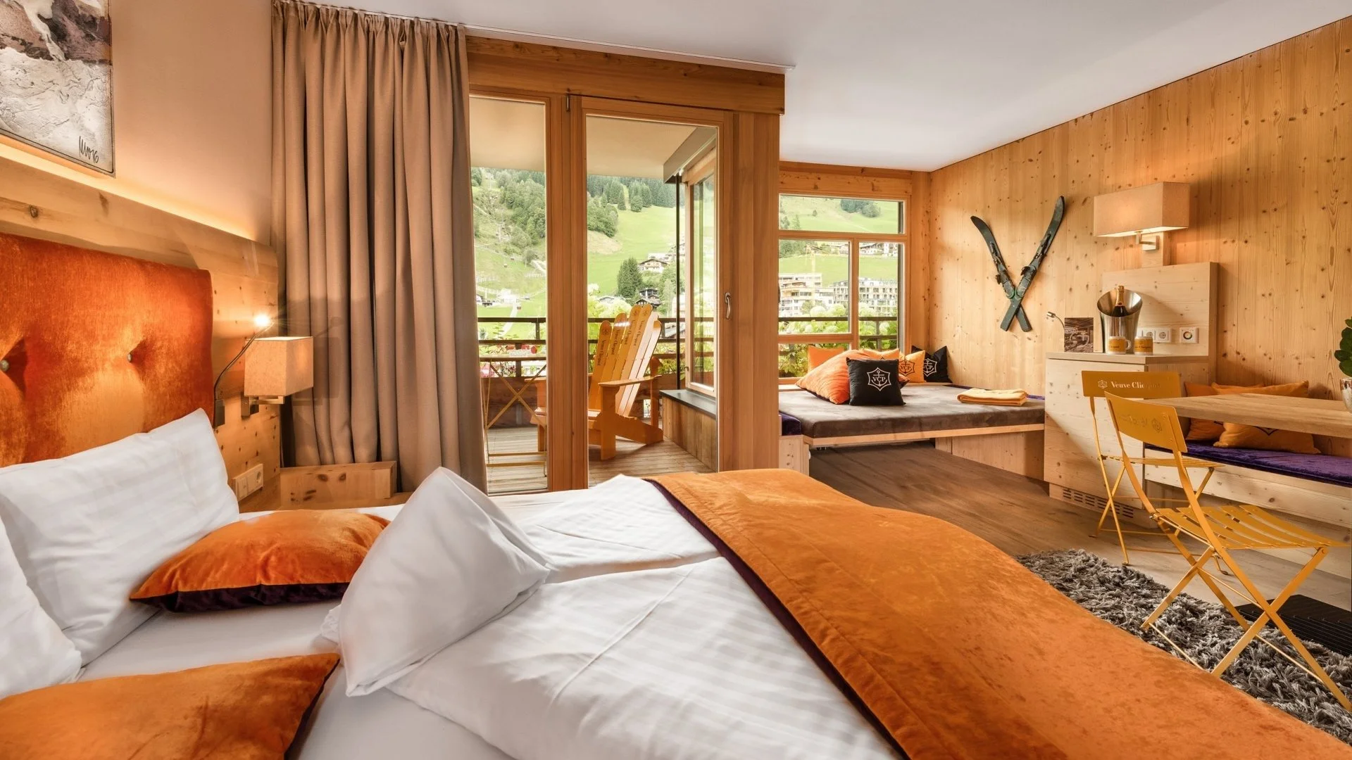 Big double bedroom with alpine interiors and large terrace. Orange bedding with office desk and space for lounging