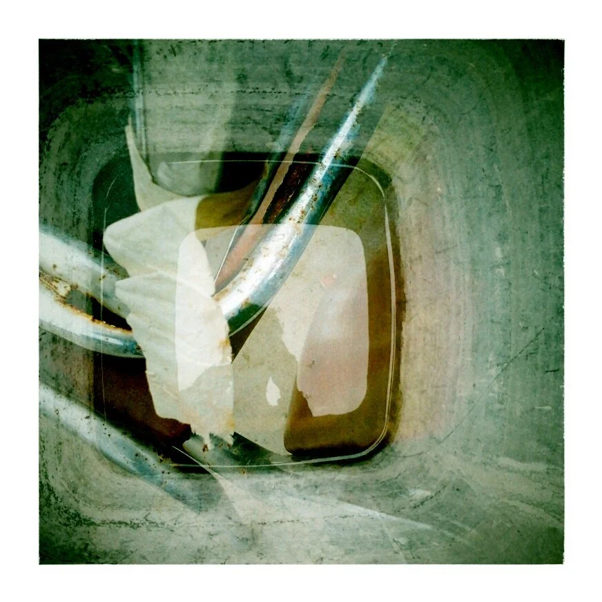 Close-up of a sink drain with a tool and paper towel inside, showing rust and grime.