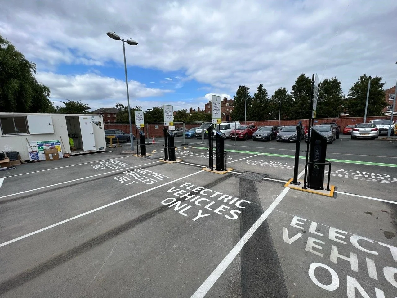 Empty car park with electric vehicle charging bays. 'Electric Vehicles Only' is painted on the tarmac floor of each bay.
