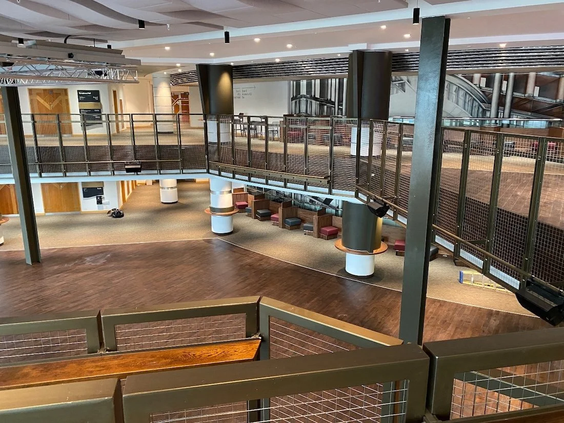 Balcony area in a large entertainment building, looking down on a performing area.