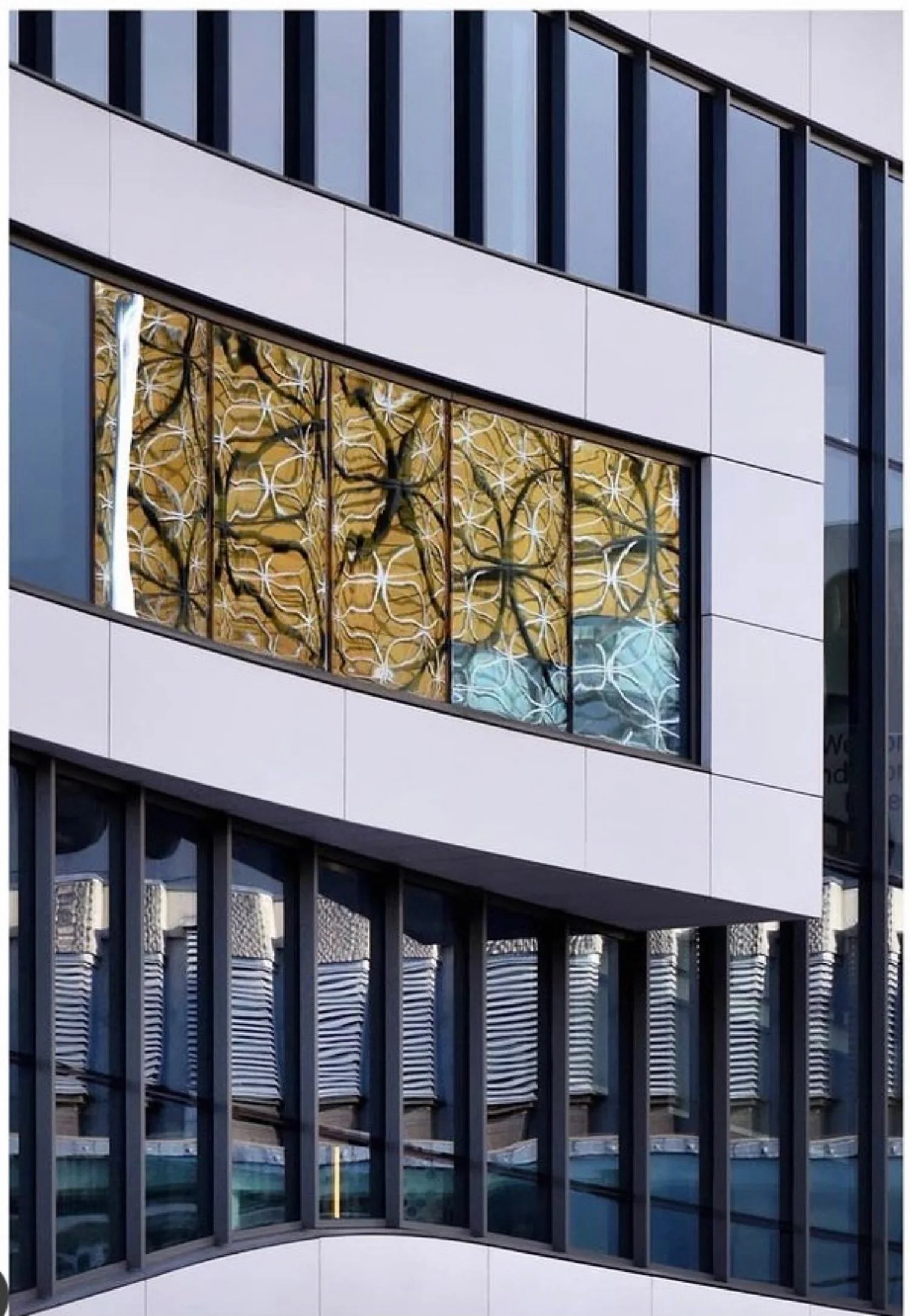 Closeup of a modern building with a built-in panel of golden and black glass.