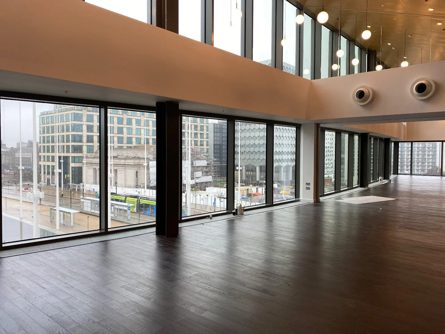An empty entertainment venue with floor to ceiling windows and wooden beams.