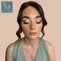 Young woman with dark hair styled in loose waves, complimented with professional makeup from KellyMarie Makeup Artist